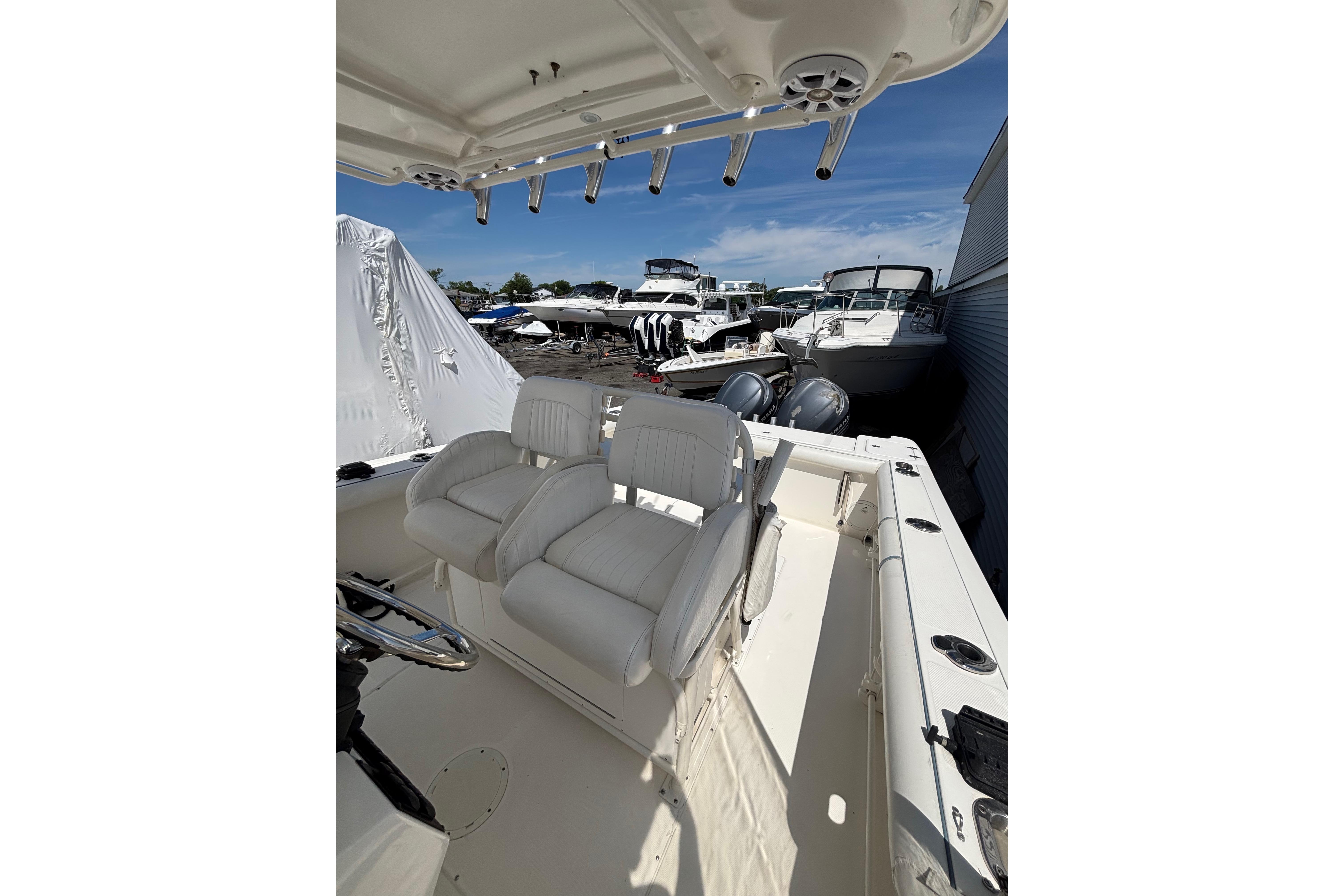 2006 Edgewater 318CC boat interior with dual seats, docked among other boats.