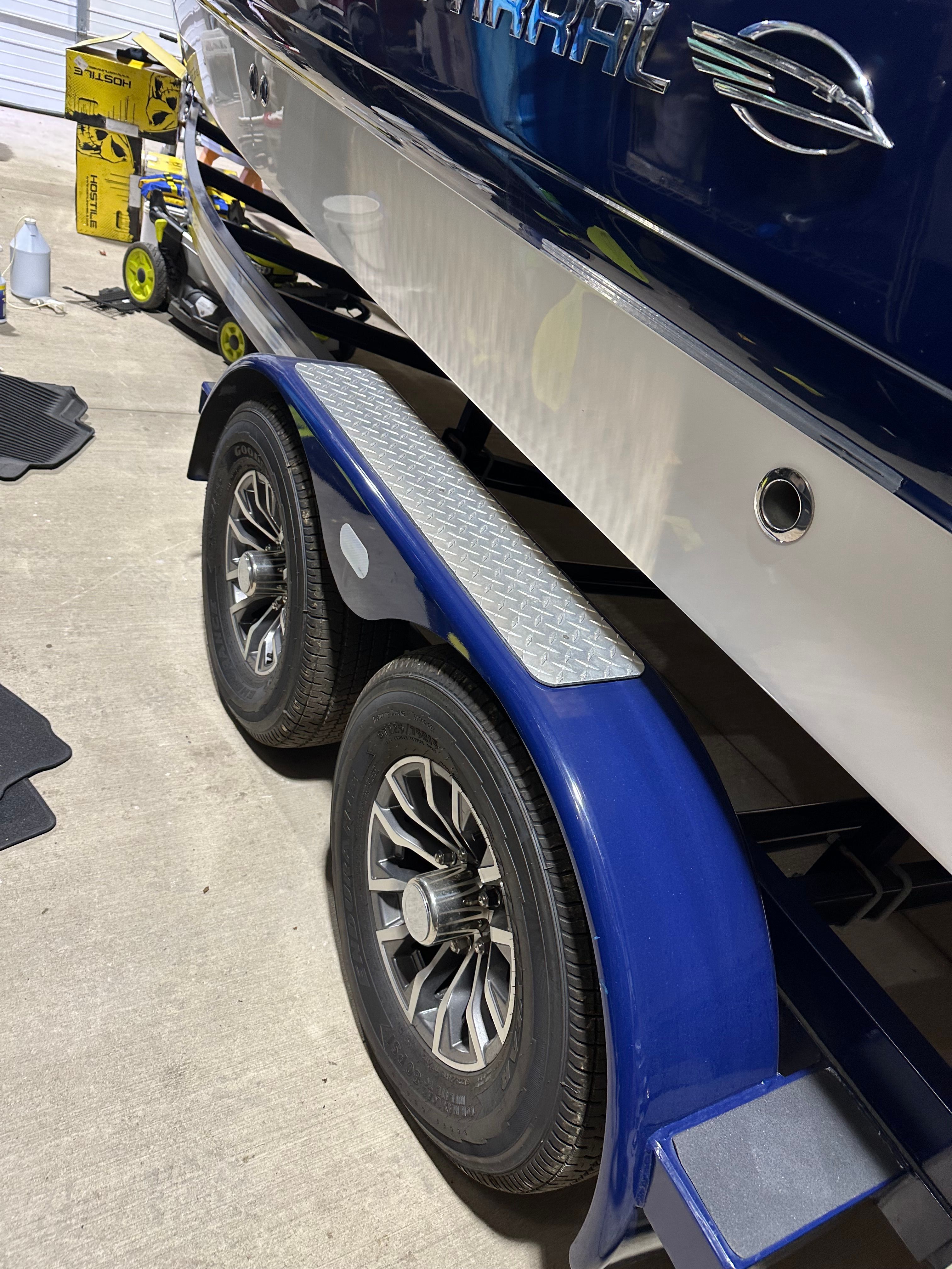 A Chaparral 287 SSX boat on a blue trailer with two wheels.