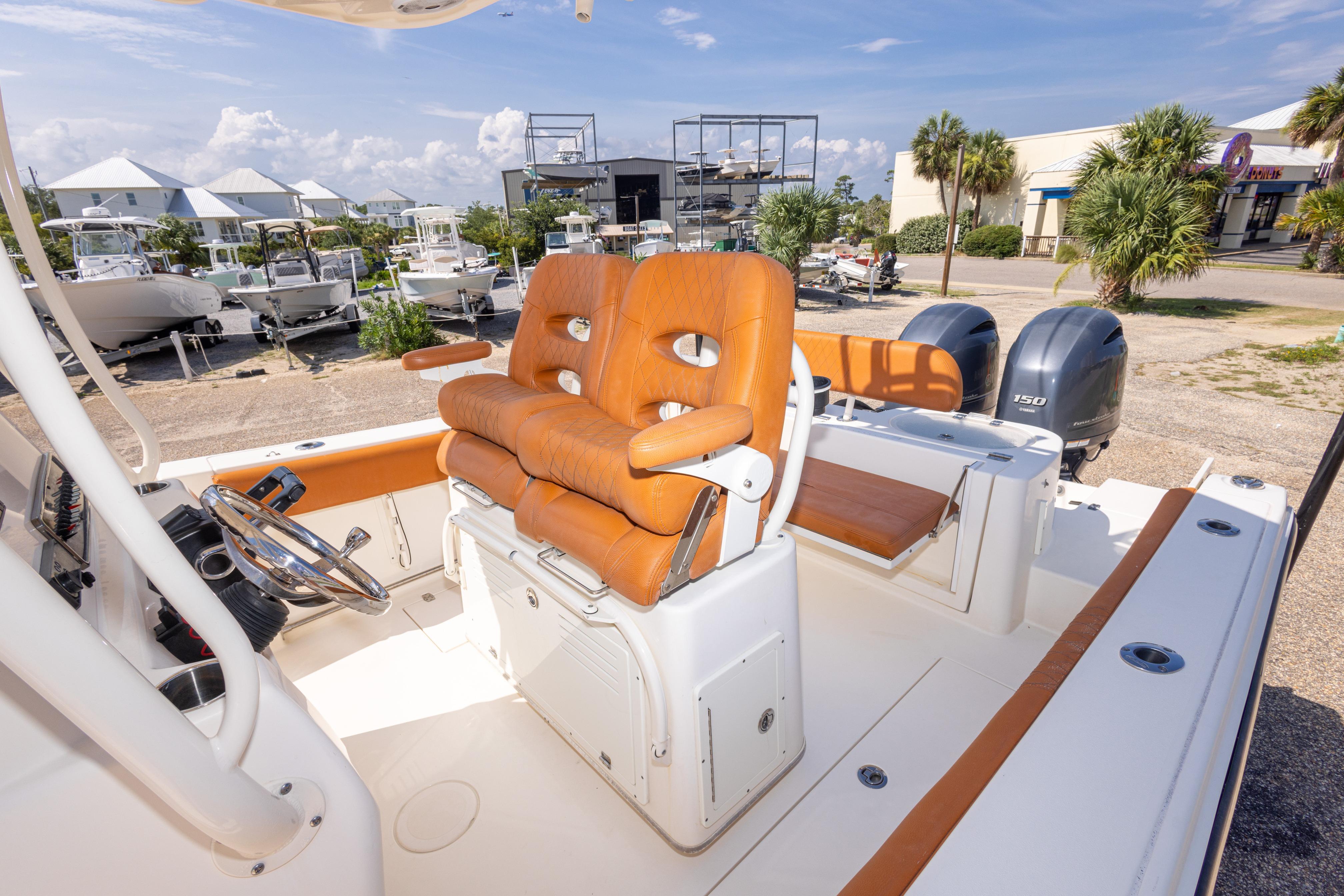 2017 Cobia 261 Center Console boat with orange seating and dual engines.