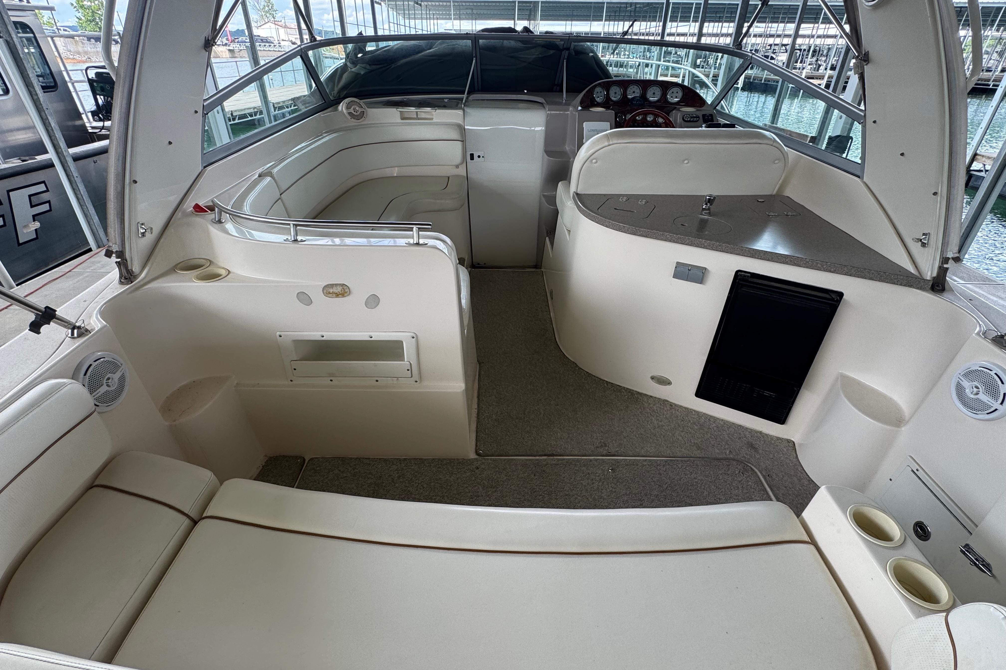 2004 Rinker Fiesta Vee 312 boat interior with seating, helm, and kitchenette area.
