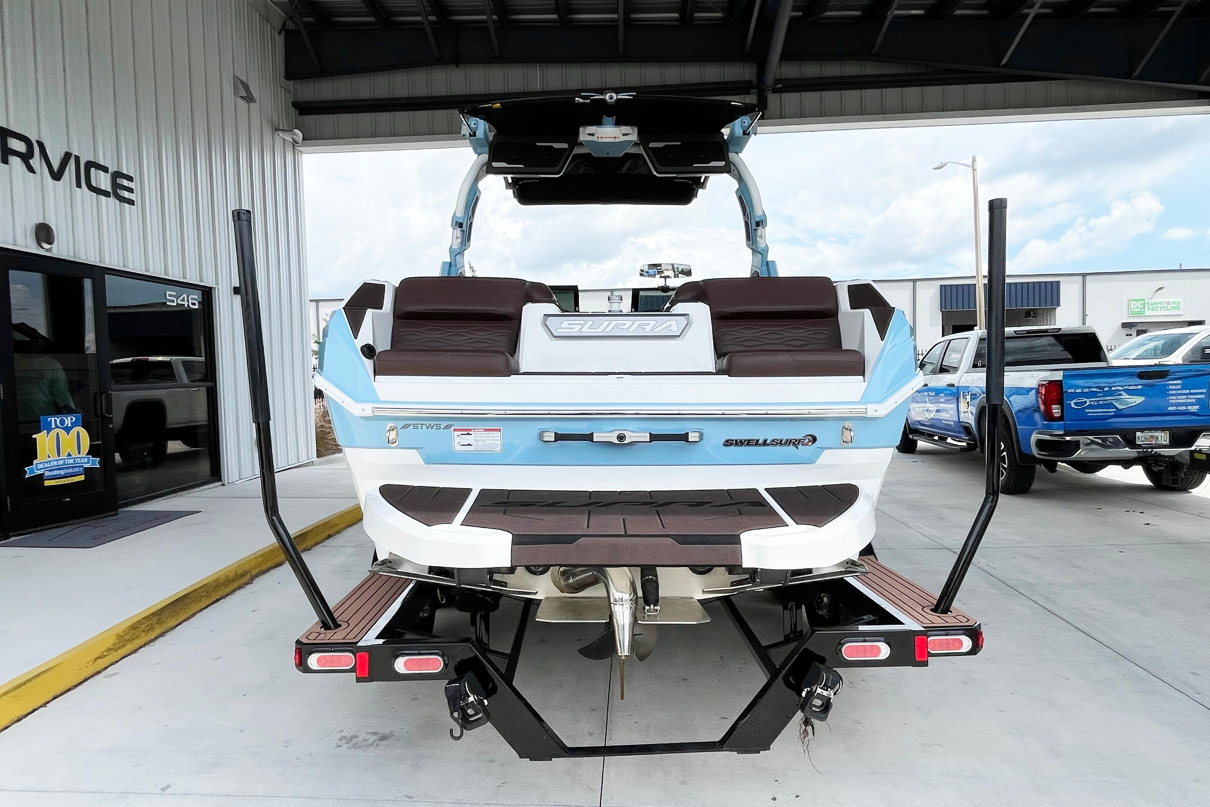 2025 Supra SA450 boat on trailer at service center, rear view.