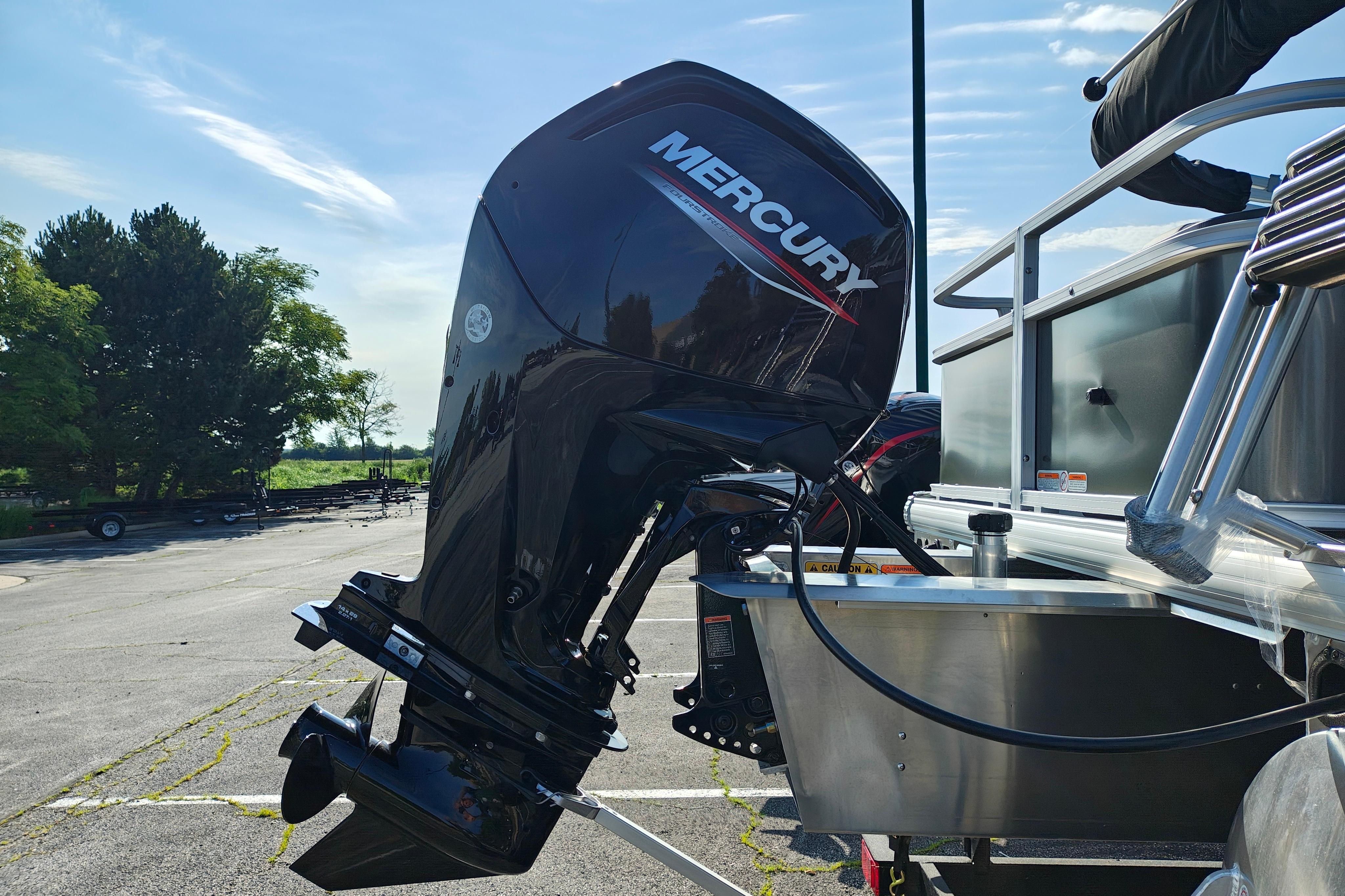 2026 Sun Tracker Bass Buggy 18 DLX with Mercury outboard motor in a parking lot.