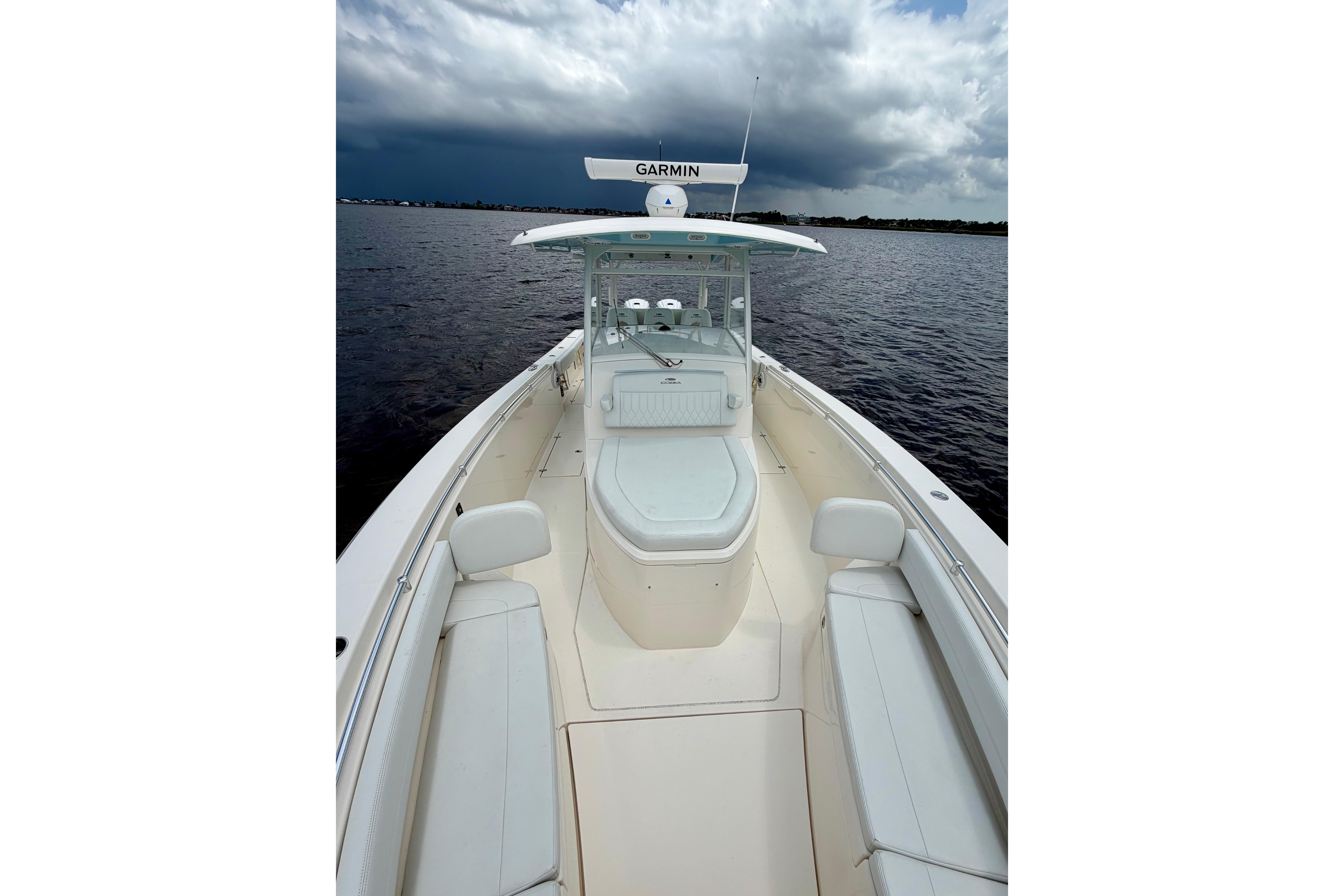 2023 Cobia 350 Center Console boat on water under cloudy sky.