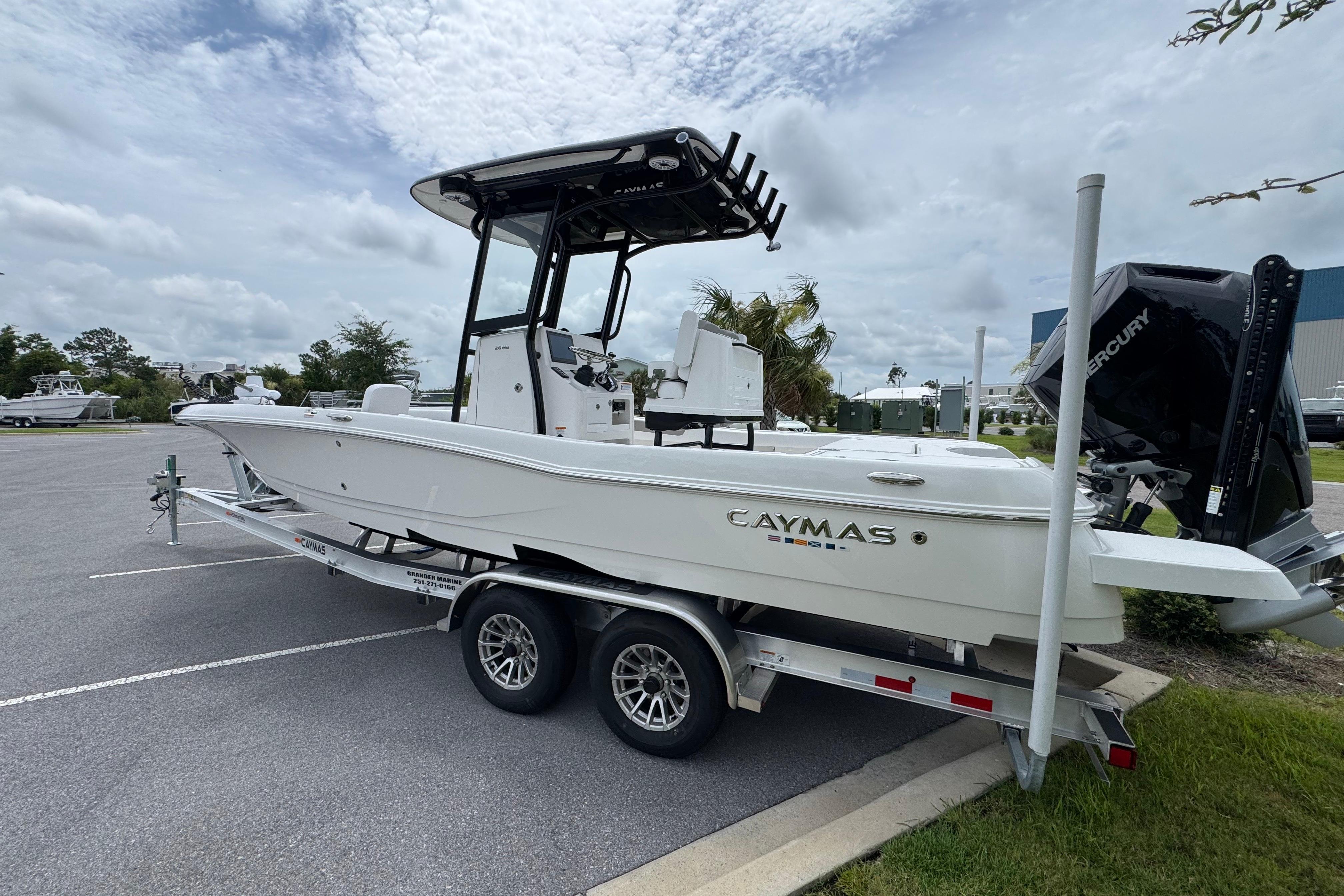 2027 Caymas 26 HB boat on trailer, parked outdoors under cloudy sky.