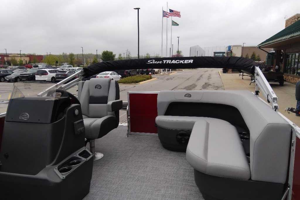 2026 Sun Tracker Party Barge 16 DLX pontoon boat with seating, parked outdoors.