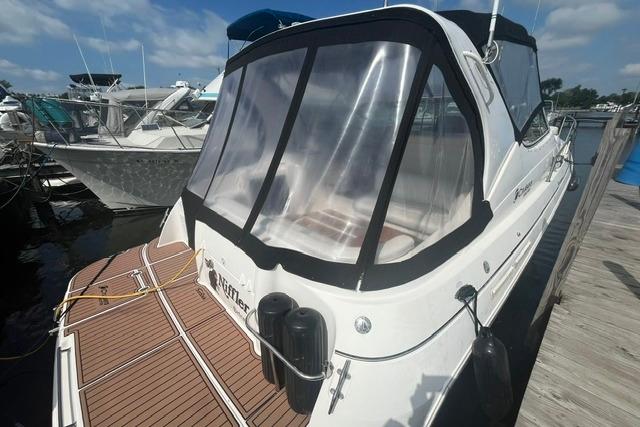 2004 Cruisers Yachts 3372 Express docked, featuring sleek design and clear canopy.