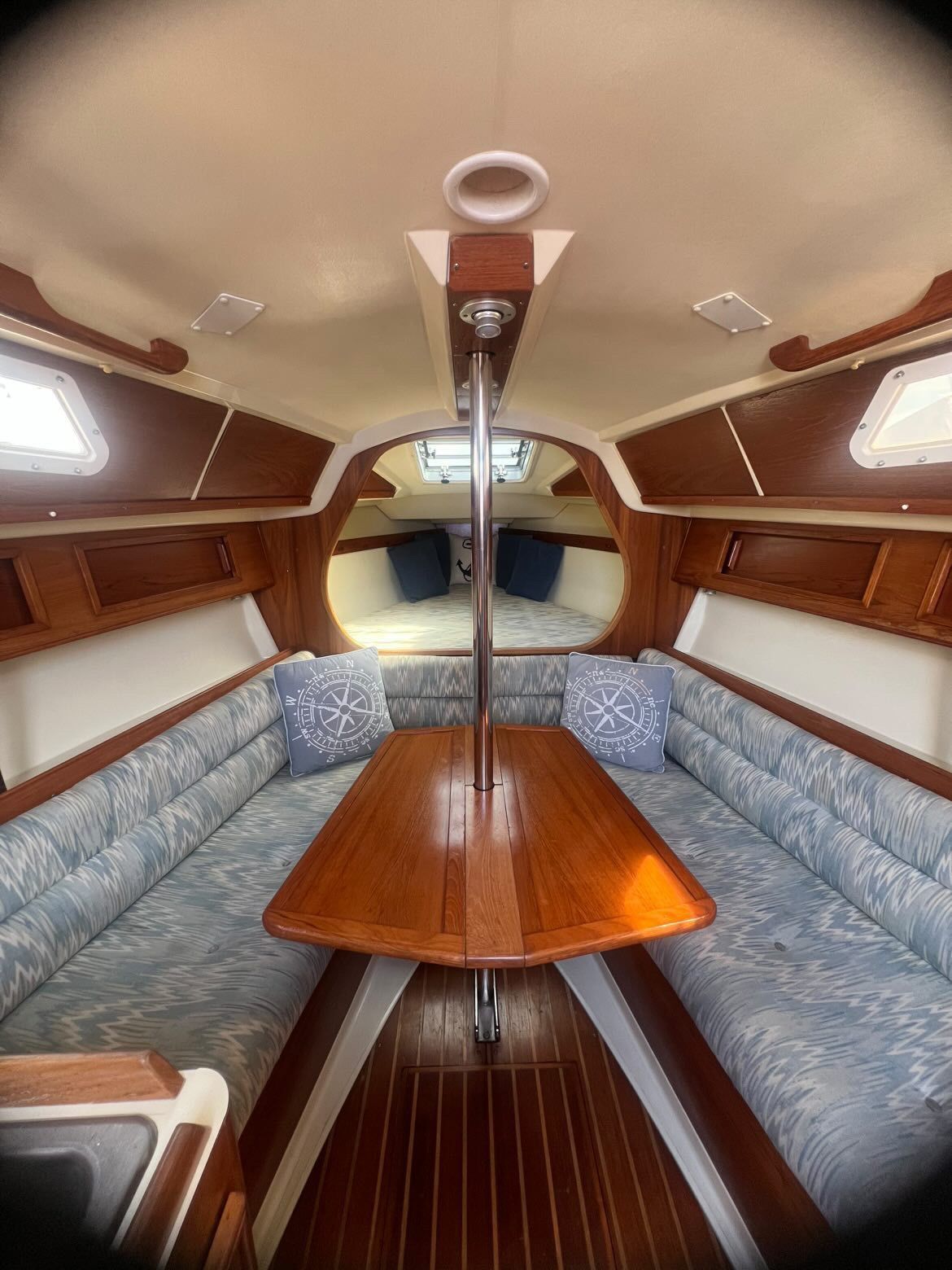 Interior of a 1988 Pearson 28 sailboat with a wooden table and cushioned seating.