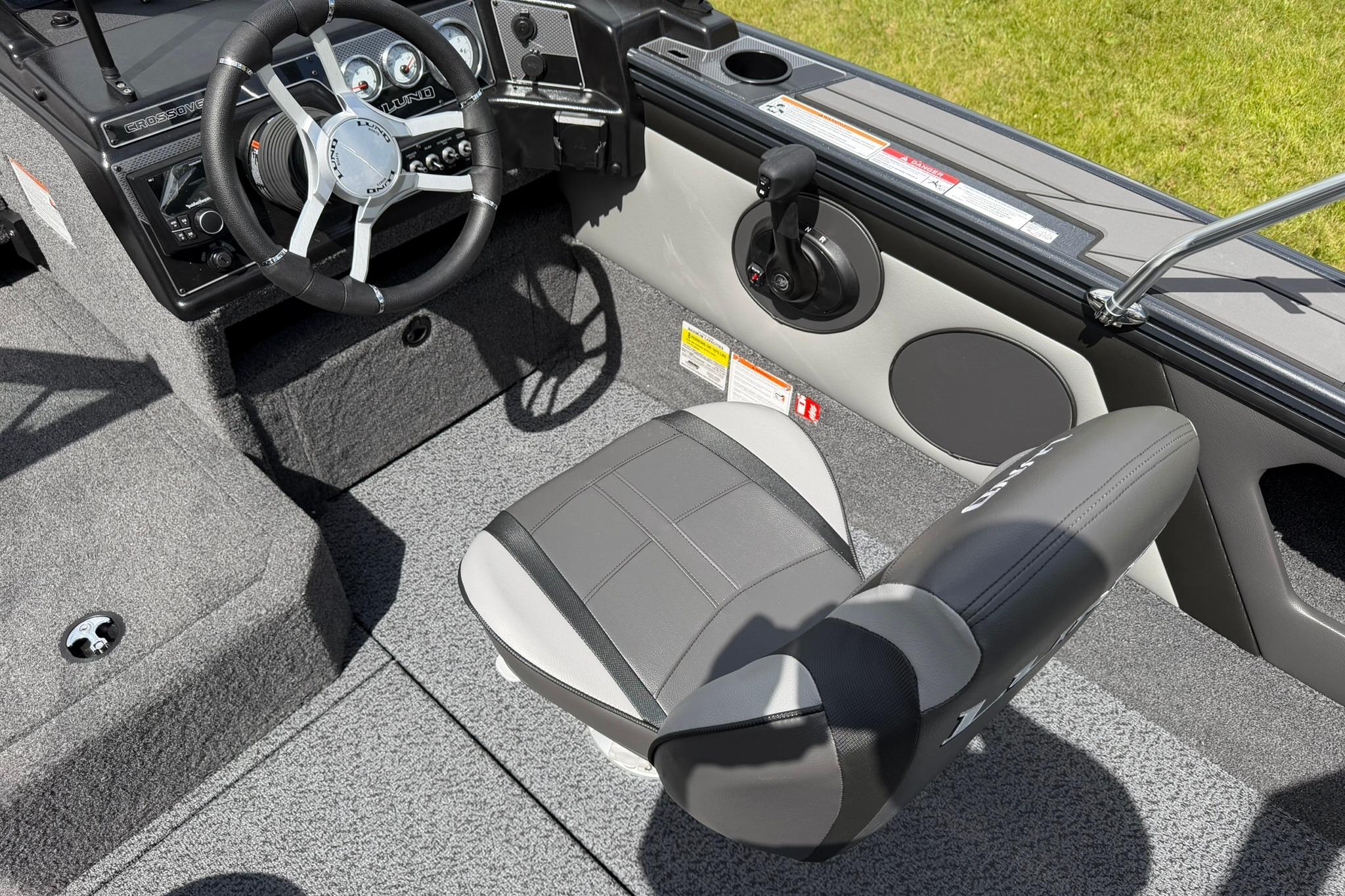 Interior of 2027 Lund 1875 Crossover XS boat with steering wheel and seat.