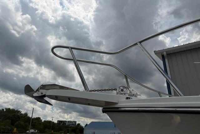2016 Parker 2520 Sport Cabin boat with anchor, under cloudy sky.
