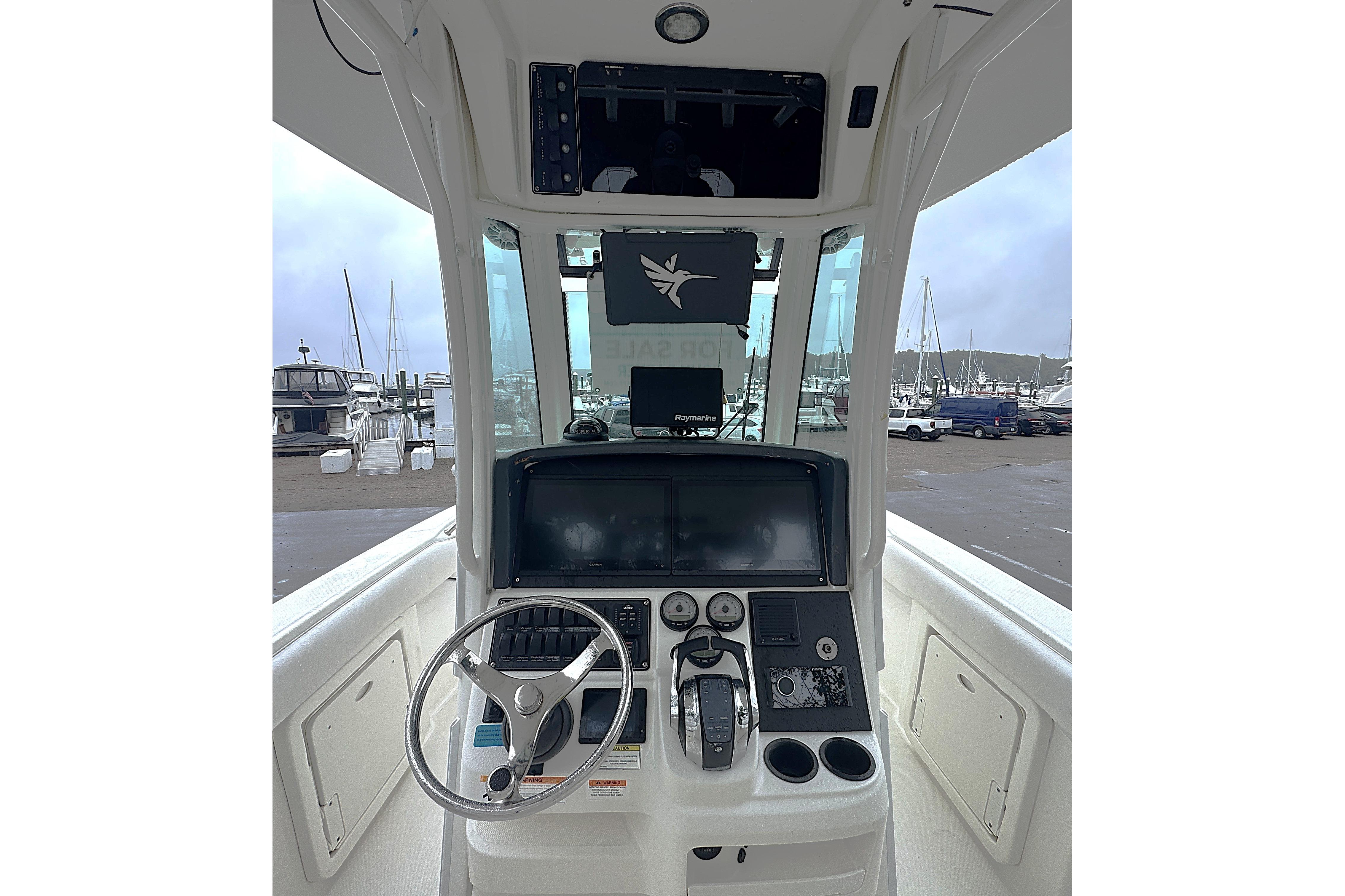2014 Boston Whaler 250 Outrage helm with steering wheel and navigation controls.