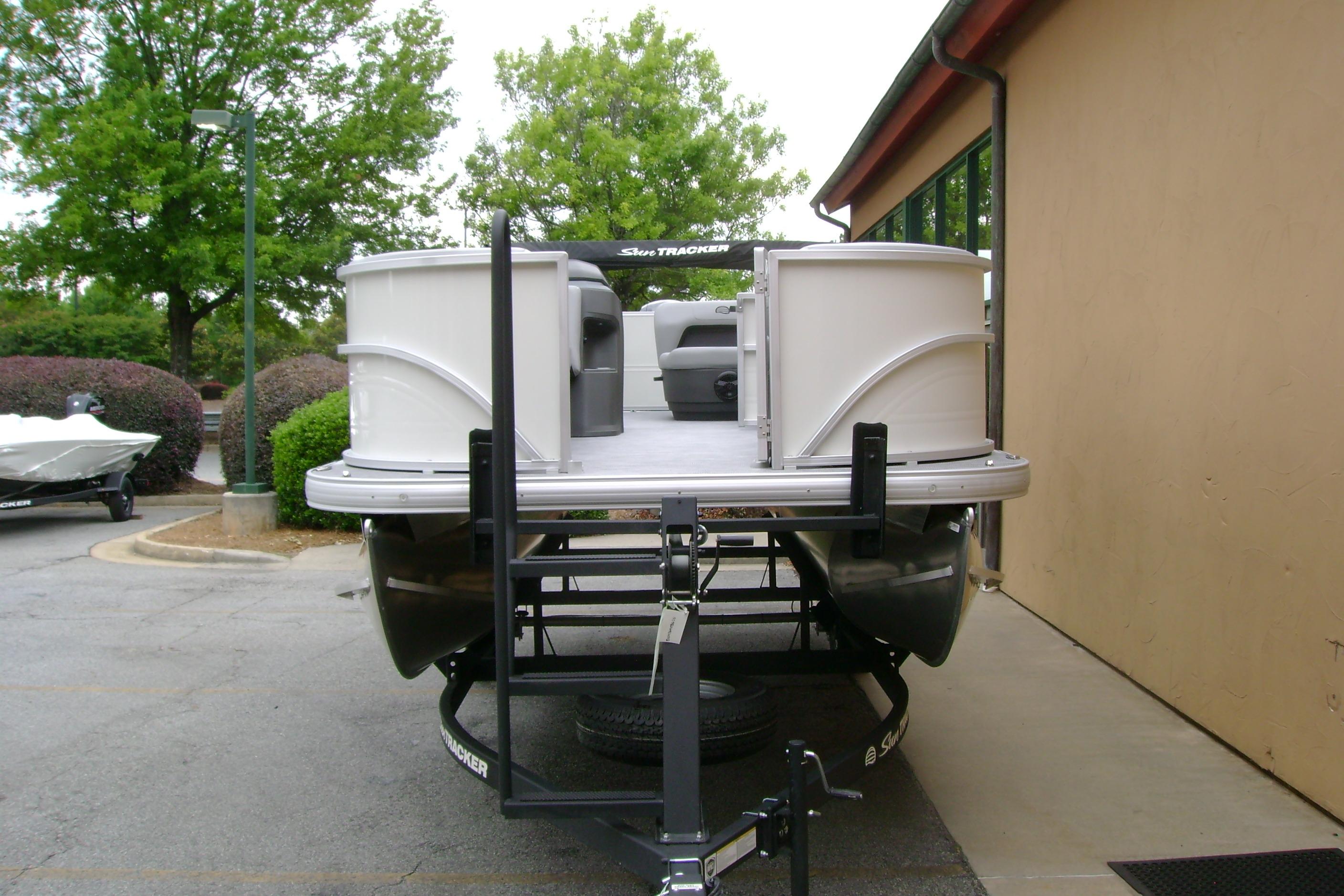 2026 Sun Tracker Party Barge 18 DLX pontoon boat on trailer, parked outdoors.