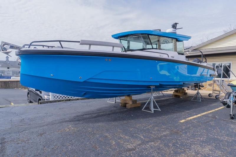 2025 Axopar 29 XC Cross Cabin boat in vibrant blue on display.