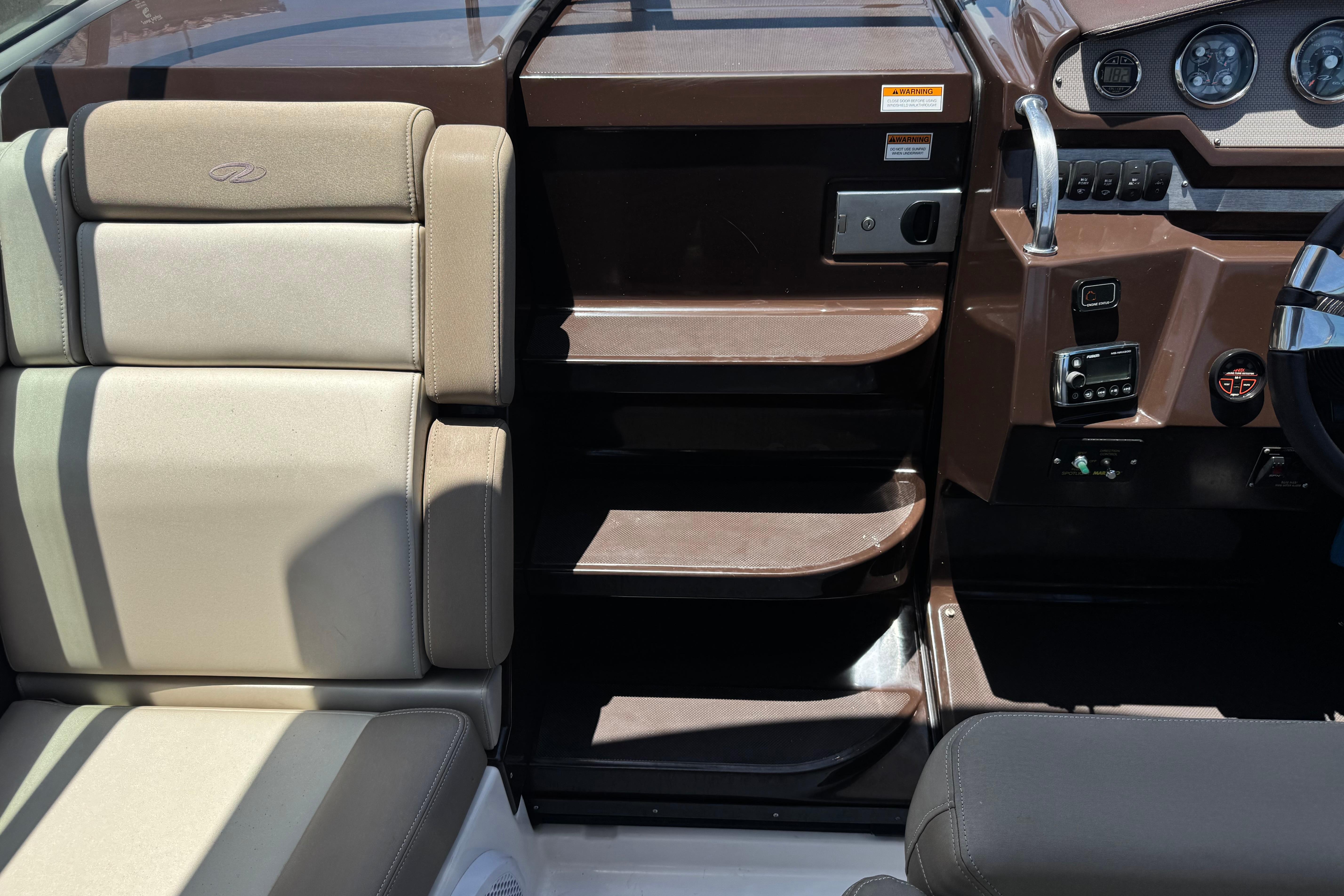 Interior view of a 2013 Regal 28 Express boat cockpit with beige seating and control panel.