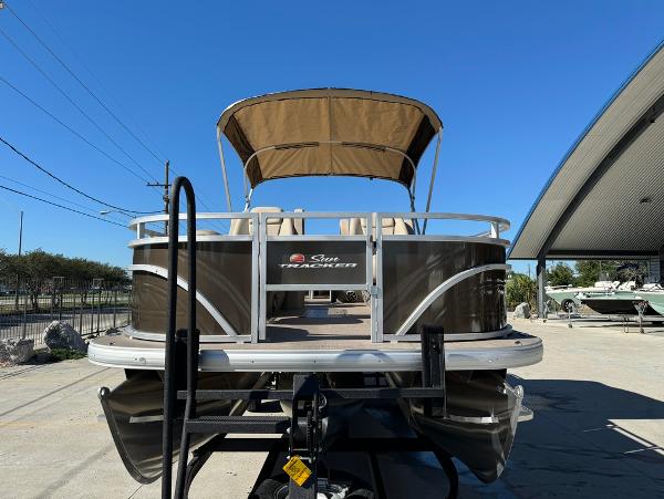 2025 Sun Tracker 24 Sportfish XP3 pontoon boat with canopy, parked outdoors.
