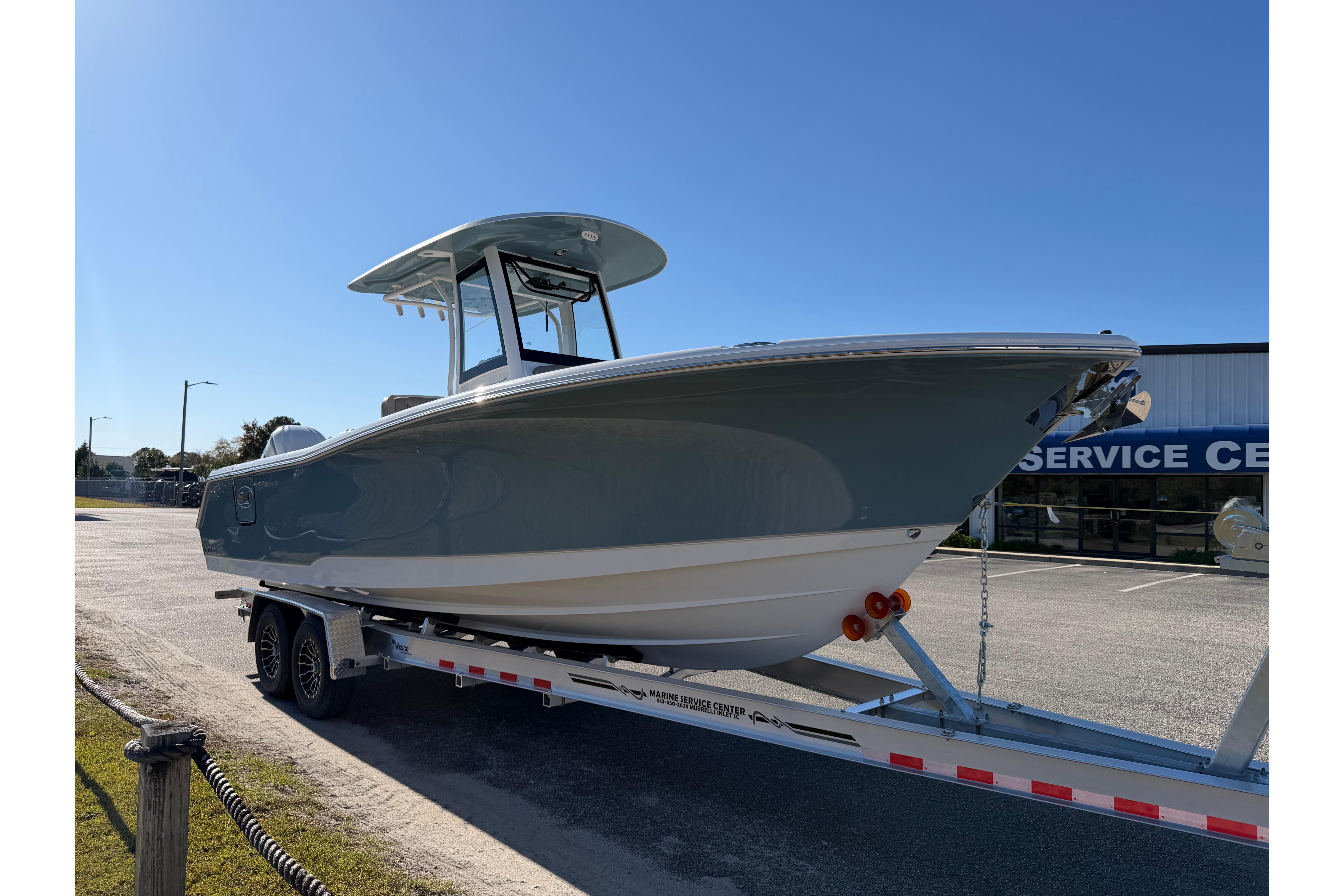 2026 Sea Hunt Ultra 275 Coffin Box boat on trailer, parked near service center.