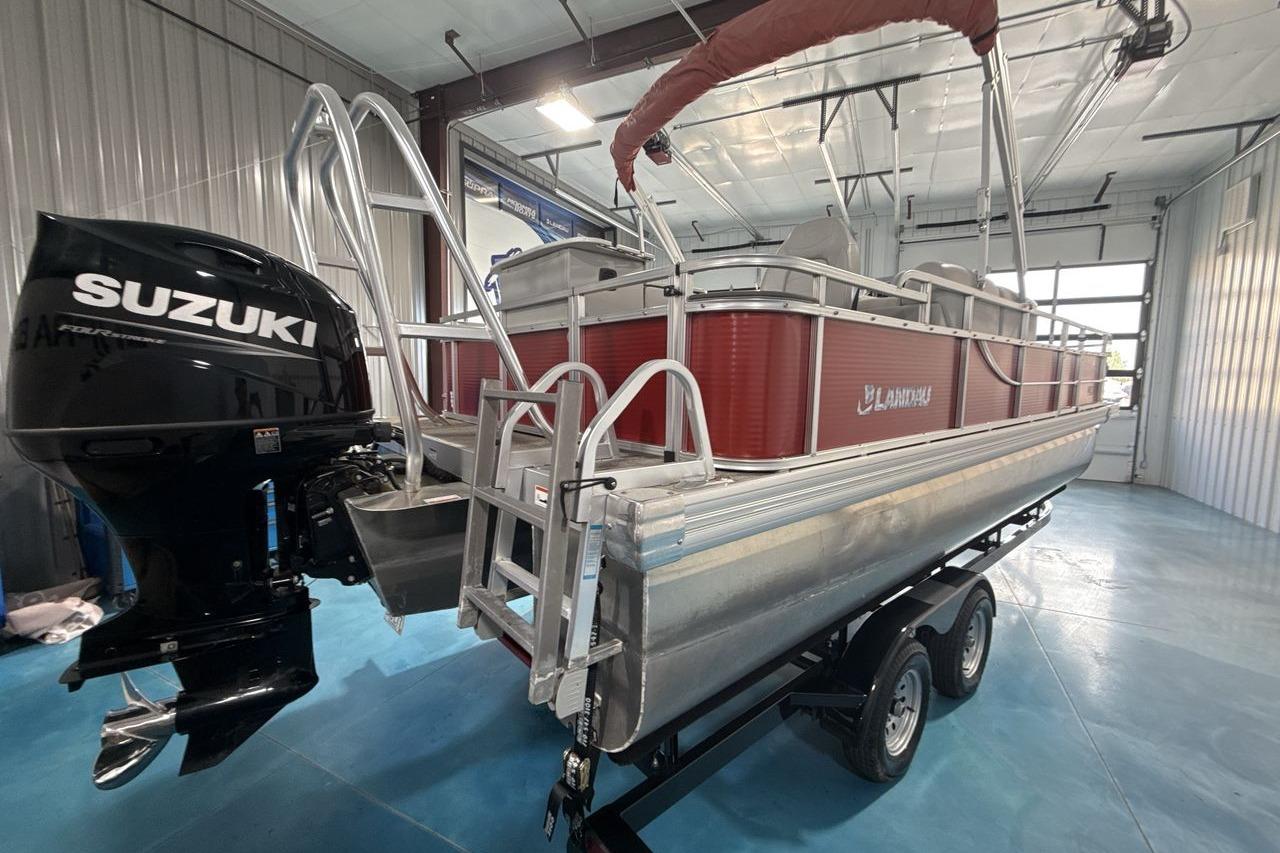 2022 Landau ALURE 232 pontoon boat with Suzuki outboard motor in a garage.
