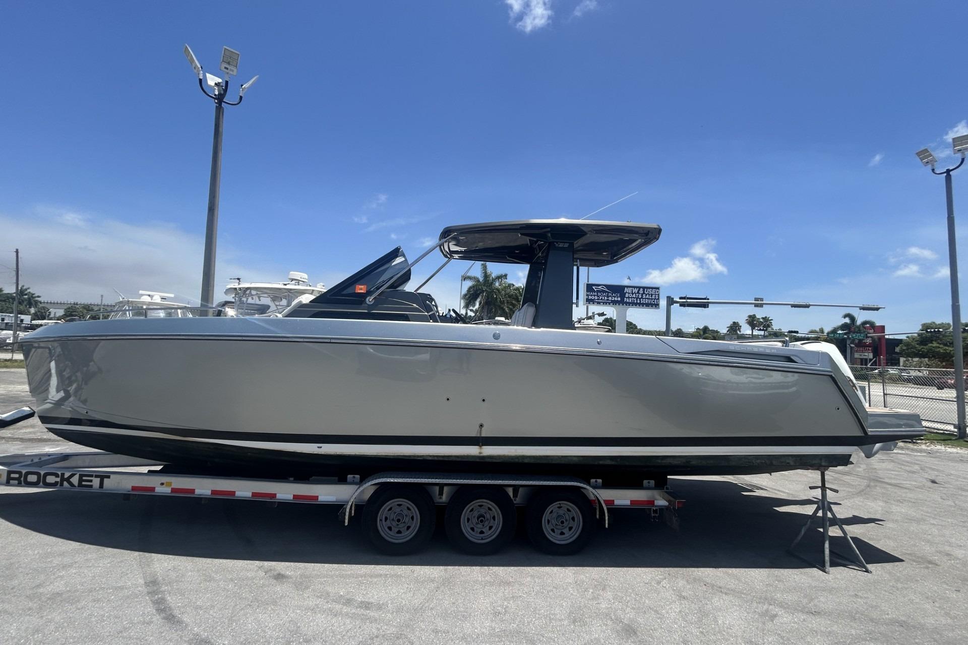 2023 Schaefer V33 boat on trailer under clear blue sky.