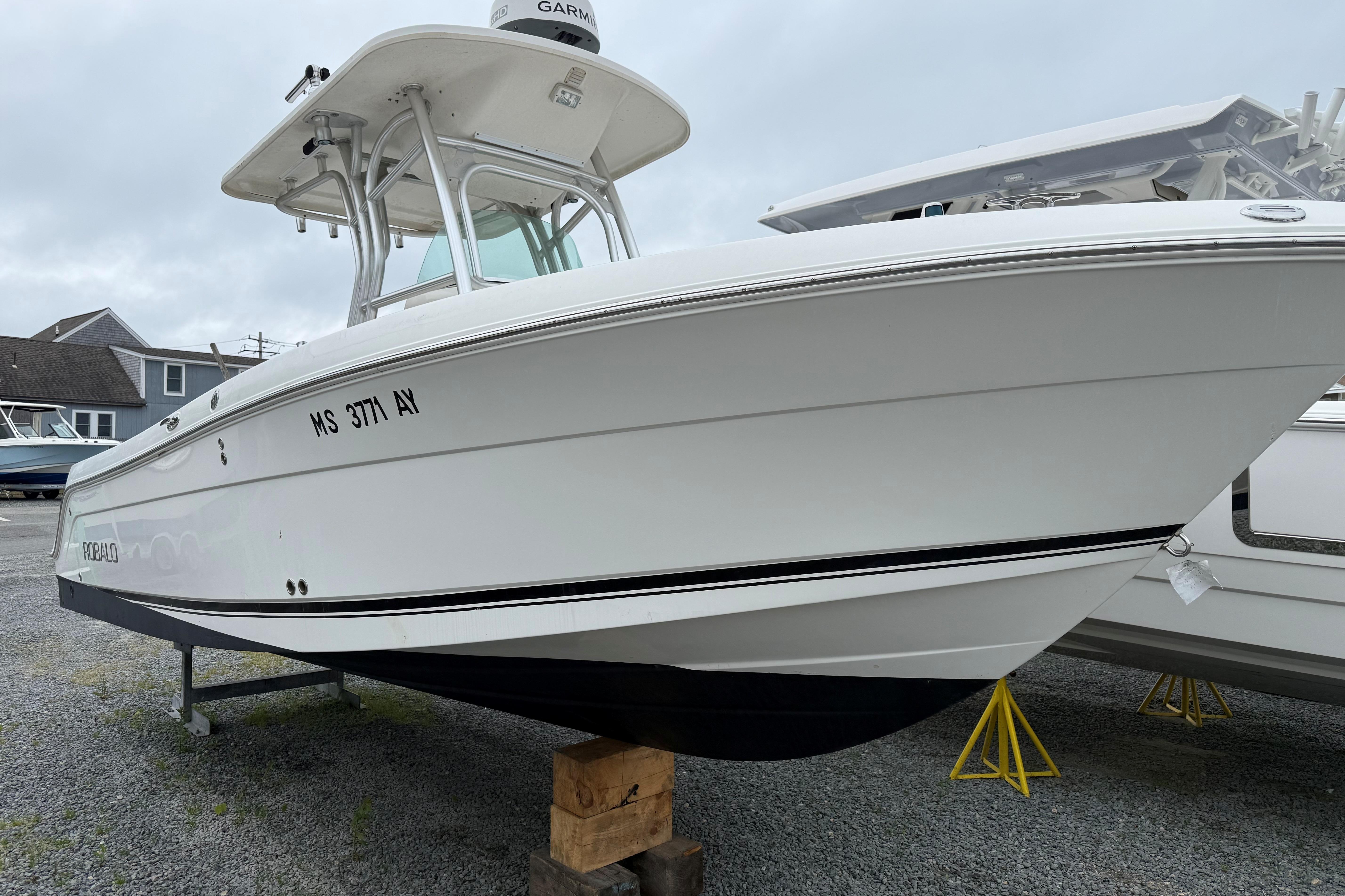 2009 Robalo R240 Center Console boat on display, white hull, parked on gravel.