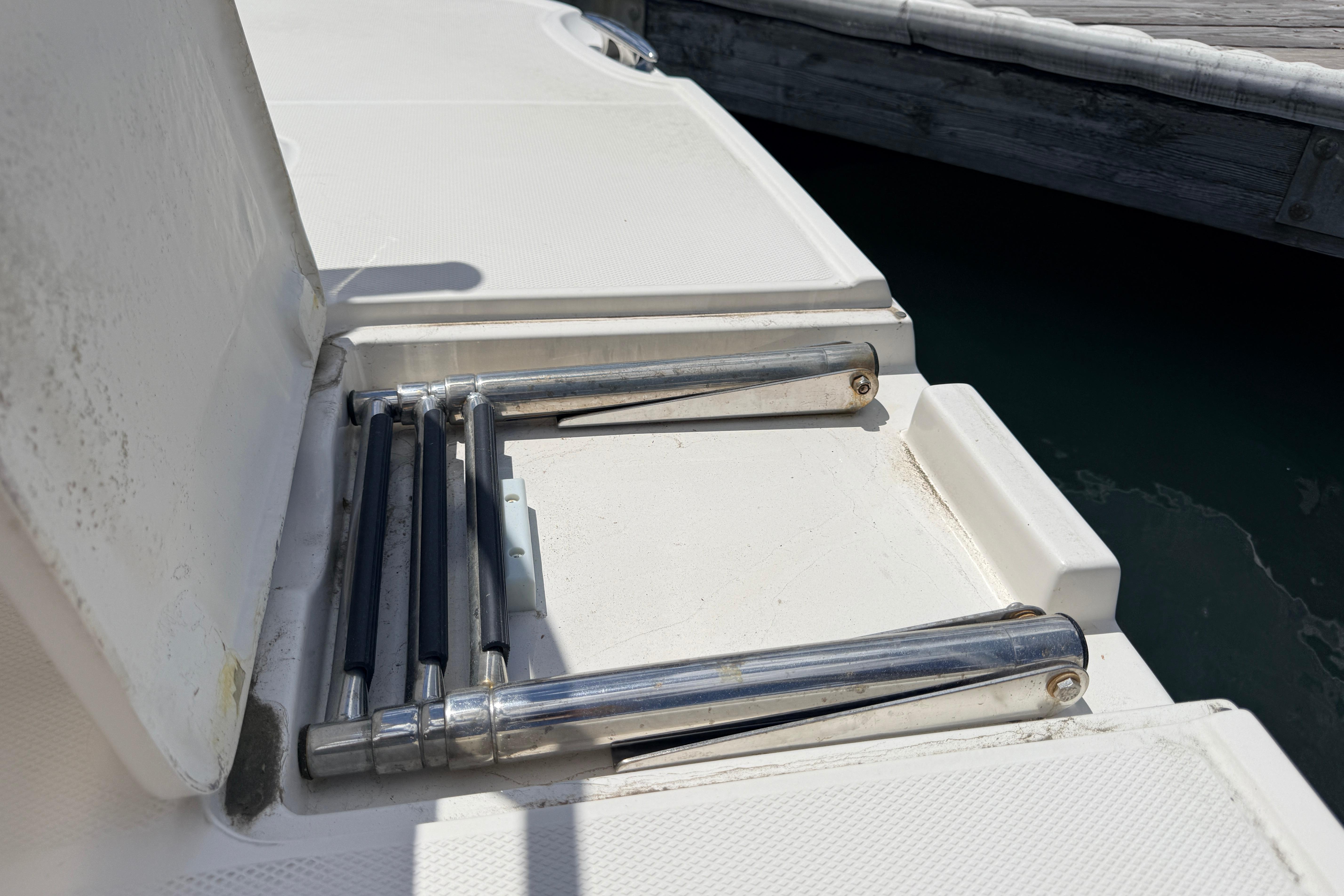 Foldable ladder on a 2011 Monterey 320 Sport Yacht, dockside view.
