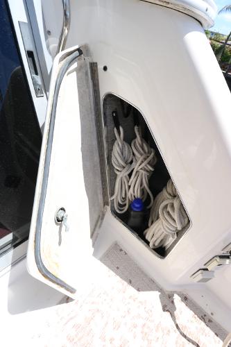 Storage compartment on a 1992 Sea Ray 350 Express Bridge boat with coiled ropes.
