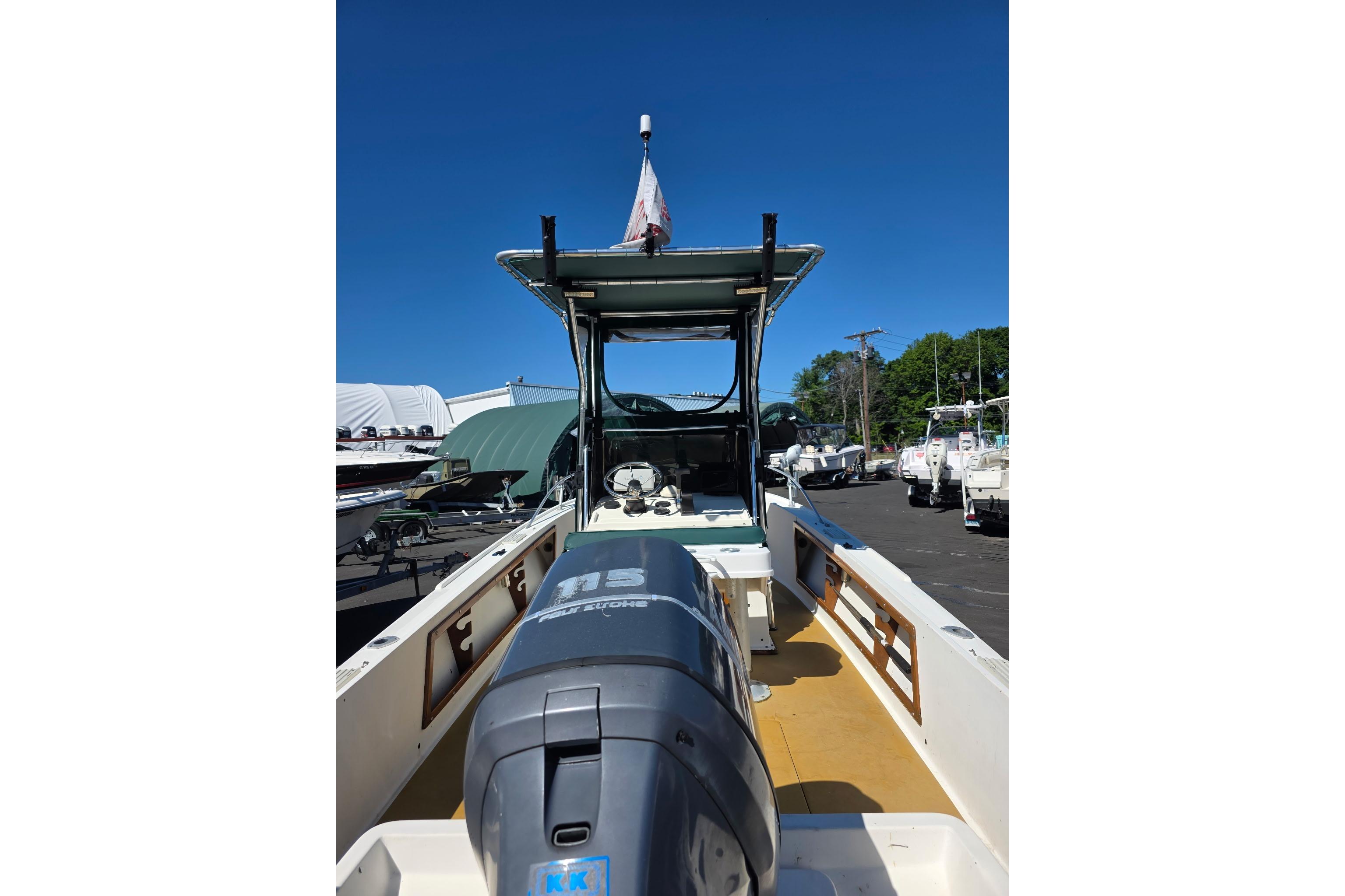 1982 Mako 20 Center Console boat with outboard motor, parked outdoors under clear blue sky.