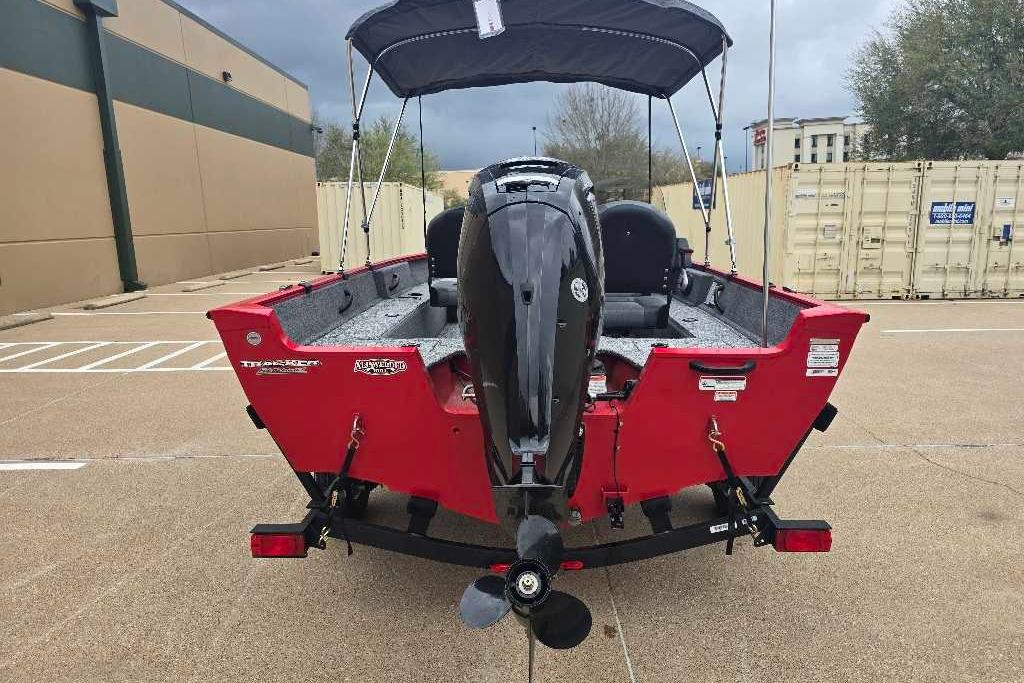2026 Tracker Pro Guide V-16 SC boat, red exterior, parked outdoors with motor visible.