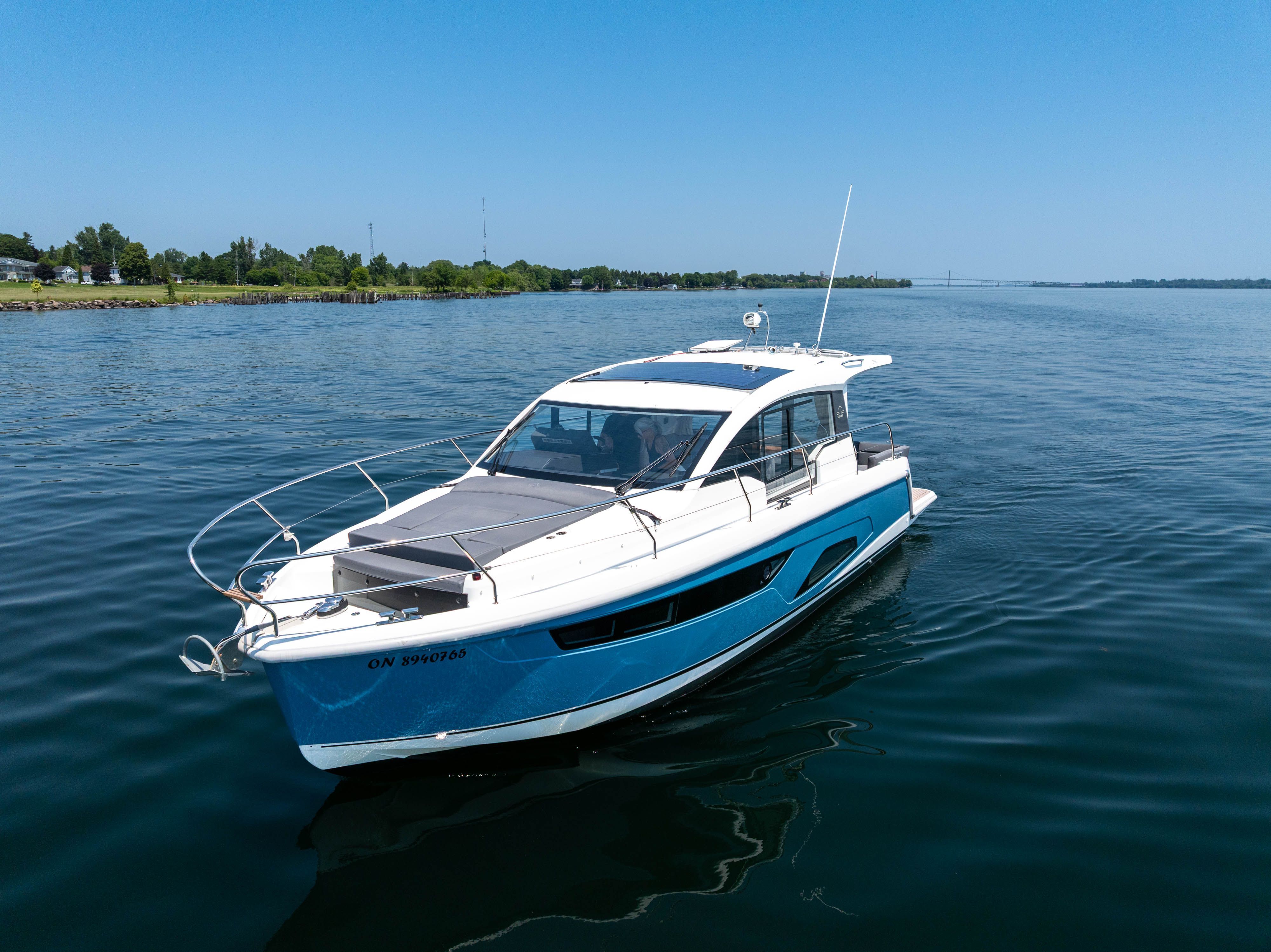 A 2023 Sealine C335V cruising on calm water under a clear sky.