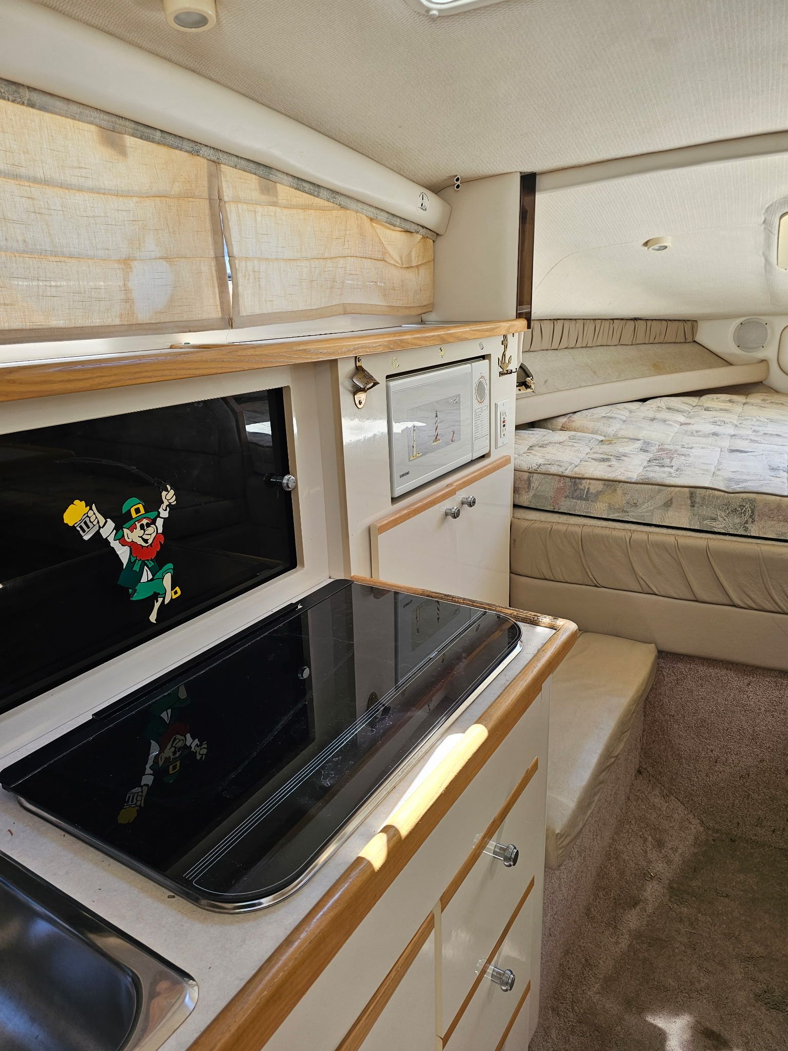 Interior of the 1998 Bayliner 2855 Ciera Sunbridge with kitchen and sleeping area.