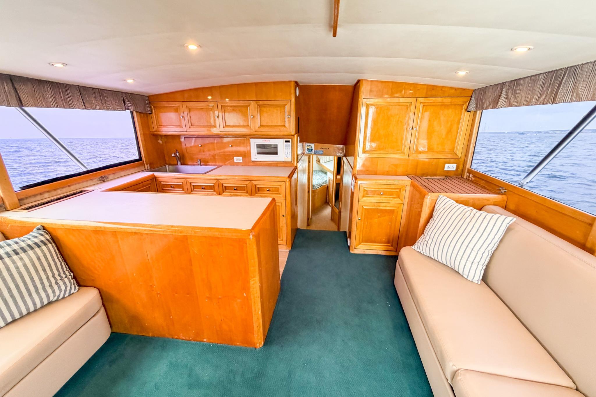 Interior of 1998 Blackwell Custom Carolina Sportfish yacht with wooden cabinetry and ocean view.