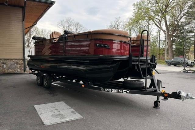 2026 Regency 230 DL pontoon boat on trailer, parked outdoors near a building.