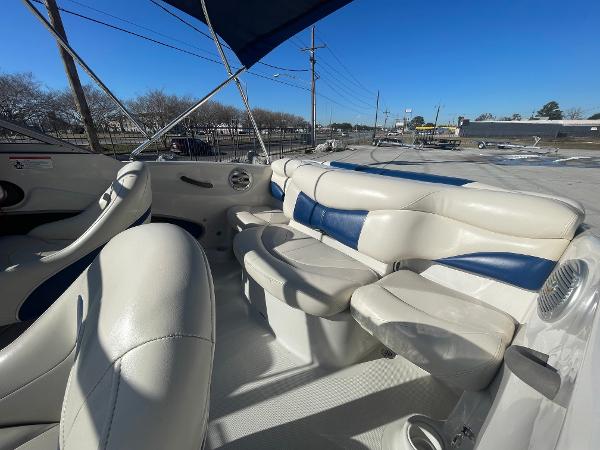 2012 Tahoe Q4 SS boat interior with white and blue seating under a clear sky.