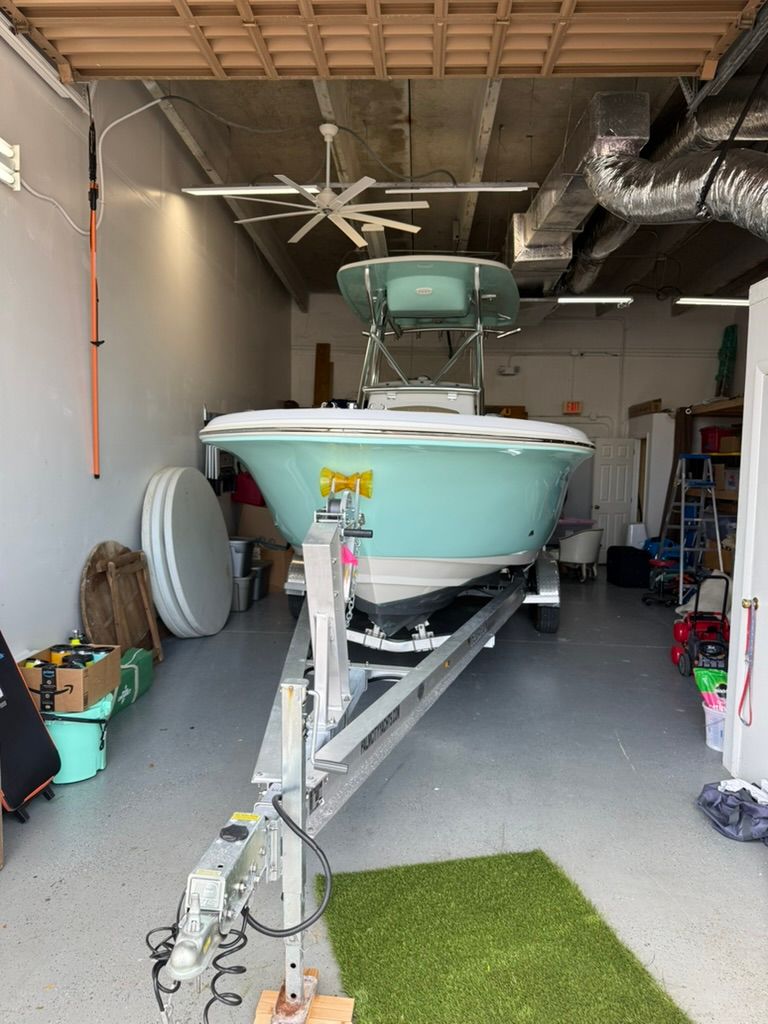 2021 Pioneer 22 SF boat in a garage on a trailer.