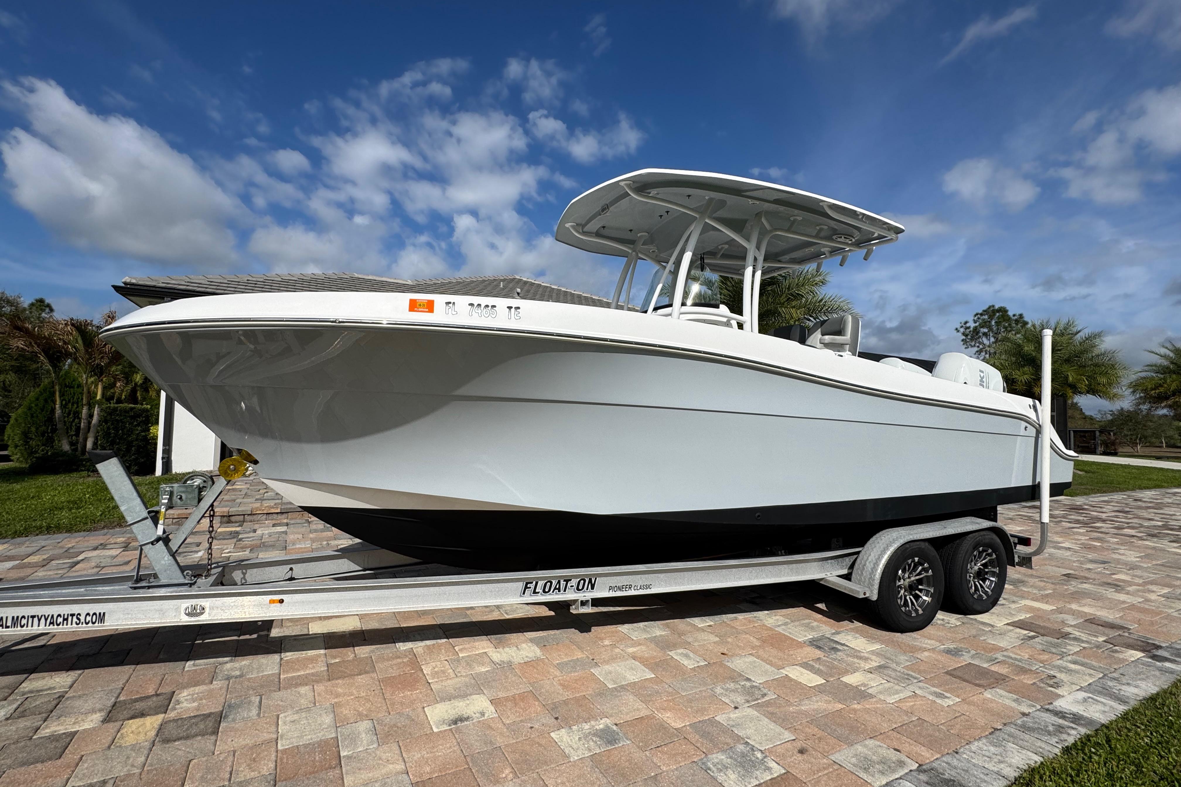 2022 Aquasport 2500 Center Console boat on trailer, parked on a sunny driveway.