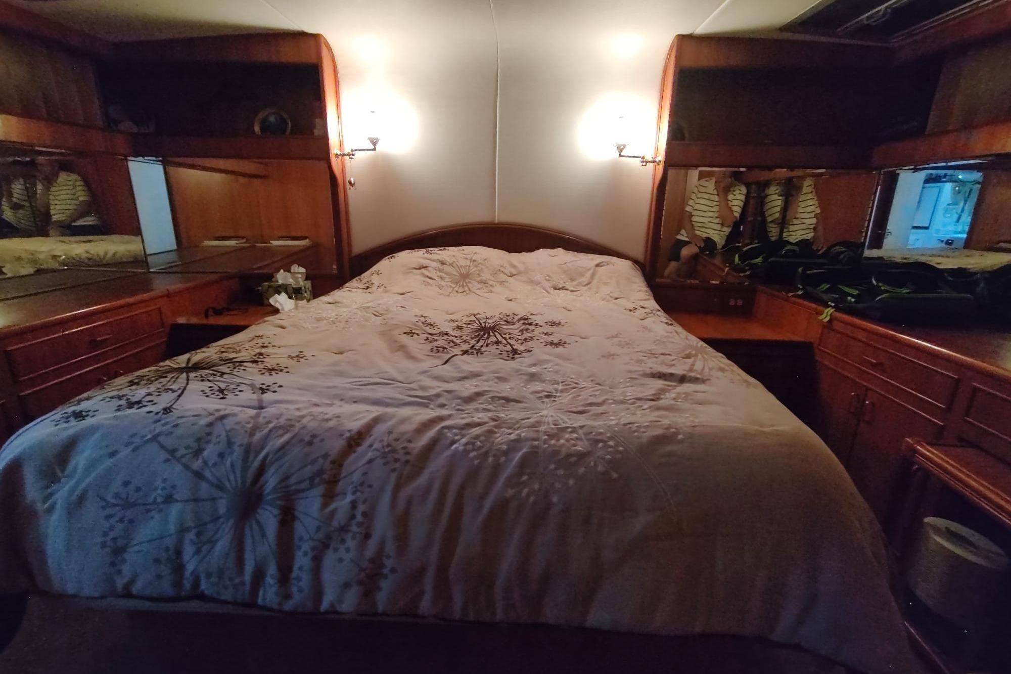 Luxurious 1989 Hyatt Double Cabin Motoryacht bedroom with elegant wood furnishings and cozy bedding.
