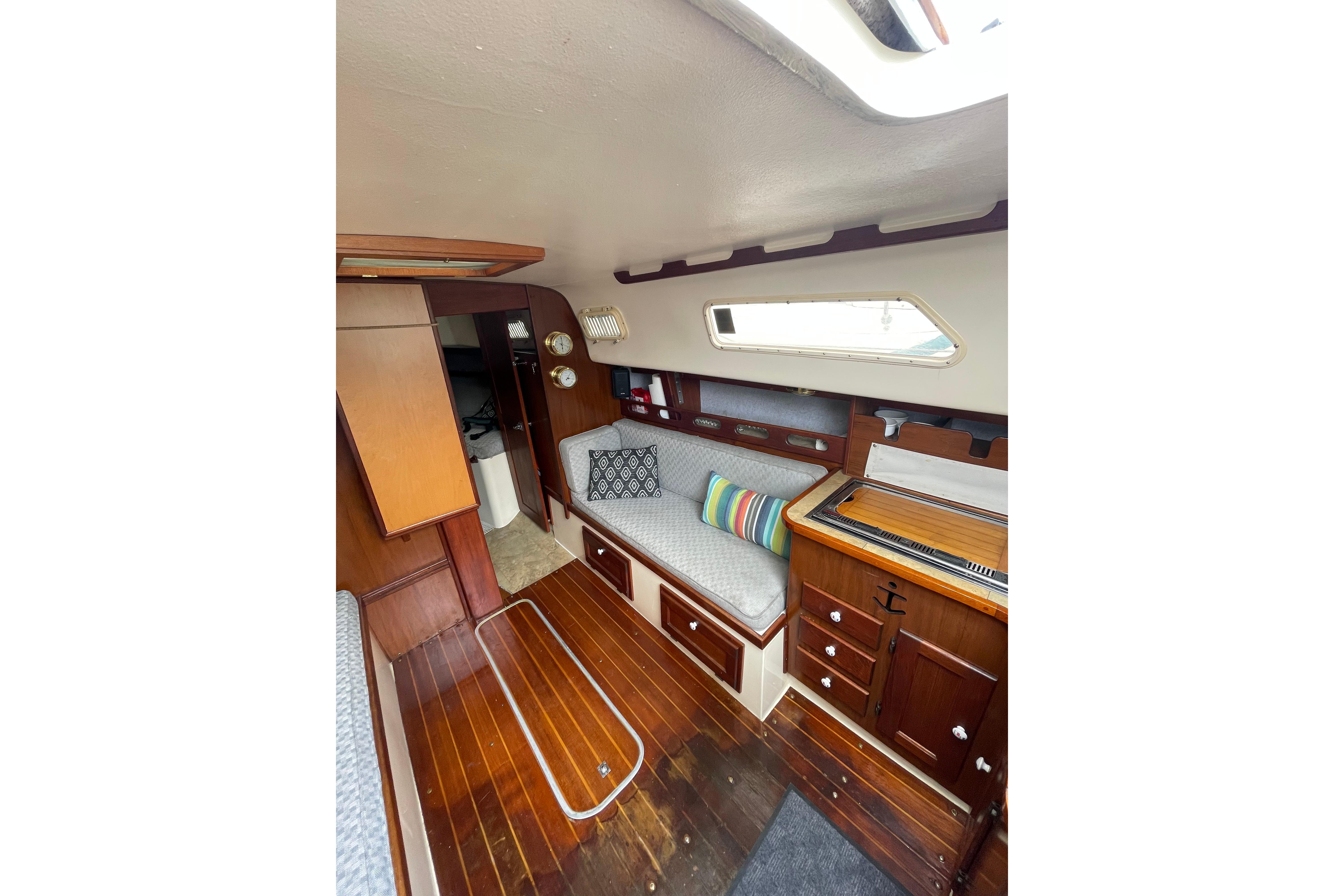 Interior of a 1978 Hunter 30 sailboat with wooden finishes and cozy seating.