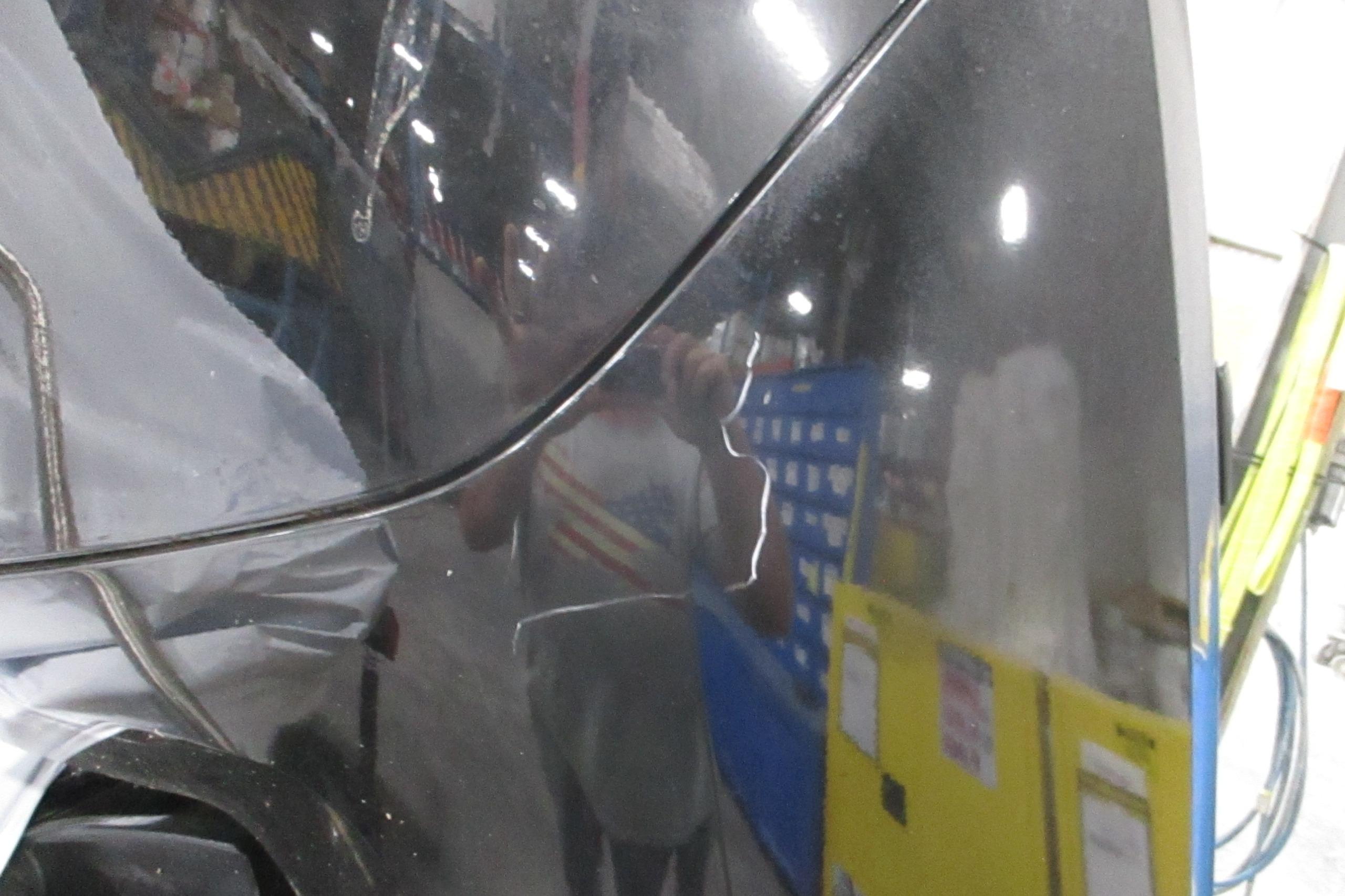 Reflection on a 2025 Tahoe T18 vehicle in a garage setting.