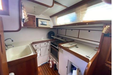 Cozy kitchen in 1997 Freedom 45 boat with wooden cabinetry and modern appliances.