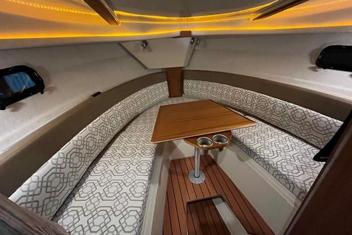 2022 Ranger Tugs R-27 cabin interior with patterned seating and wooden table.