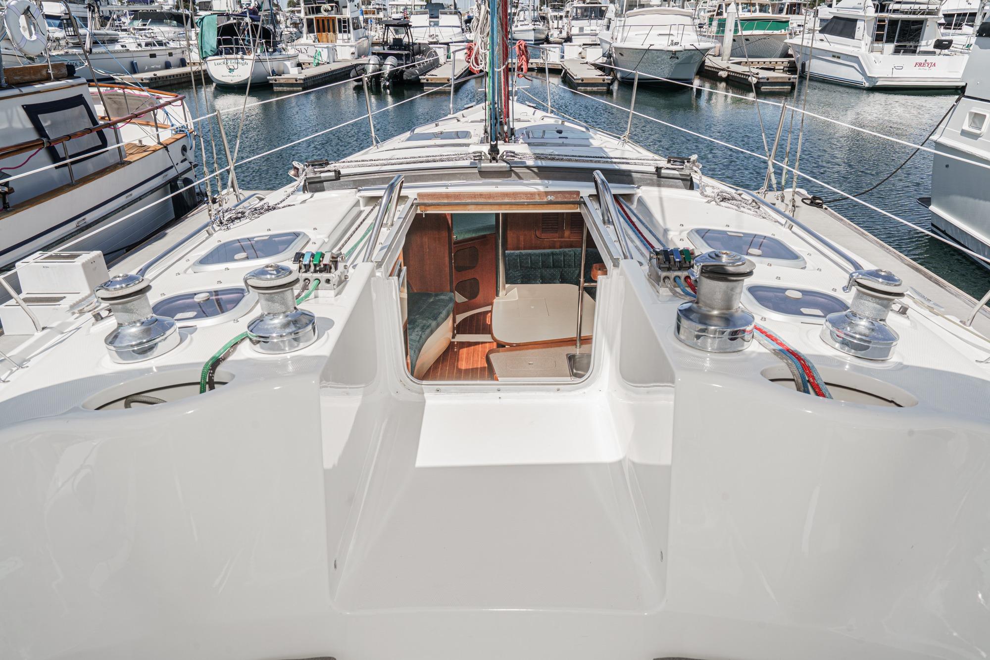 Hunter 376 sailboat deck, 1996 model, docked in a marina with visible winches and cabin entrance.