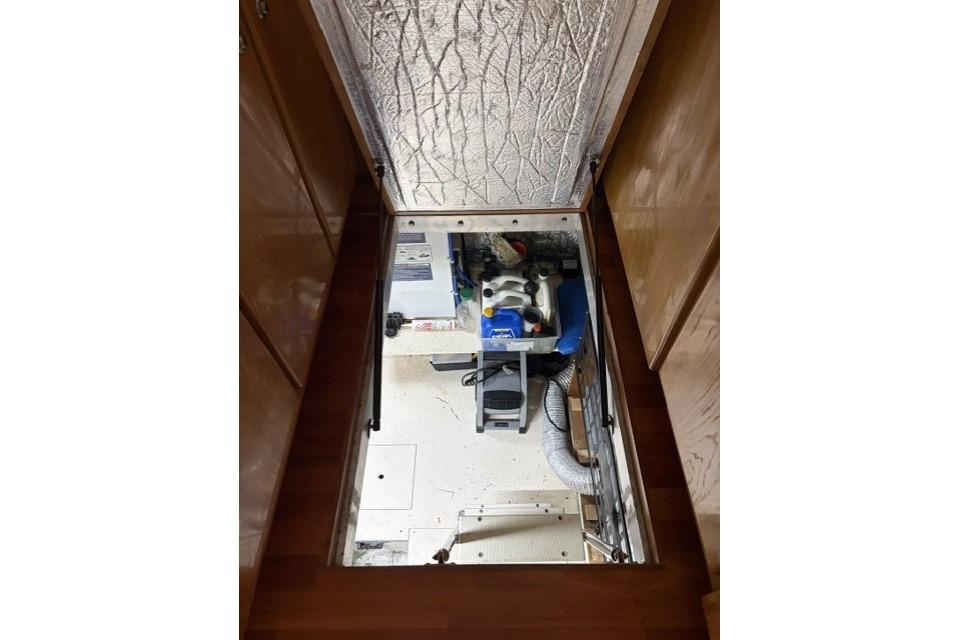 Engine room of a 2007 Navigator 5100 yacht, featuring mechanical equipment and storage.