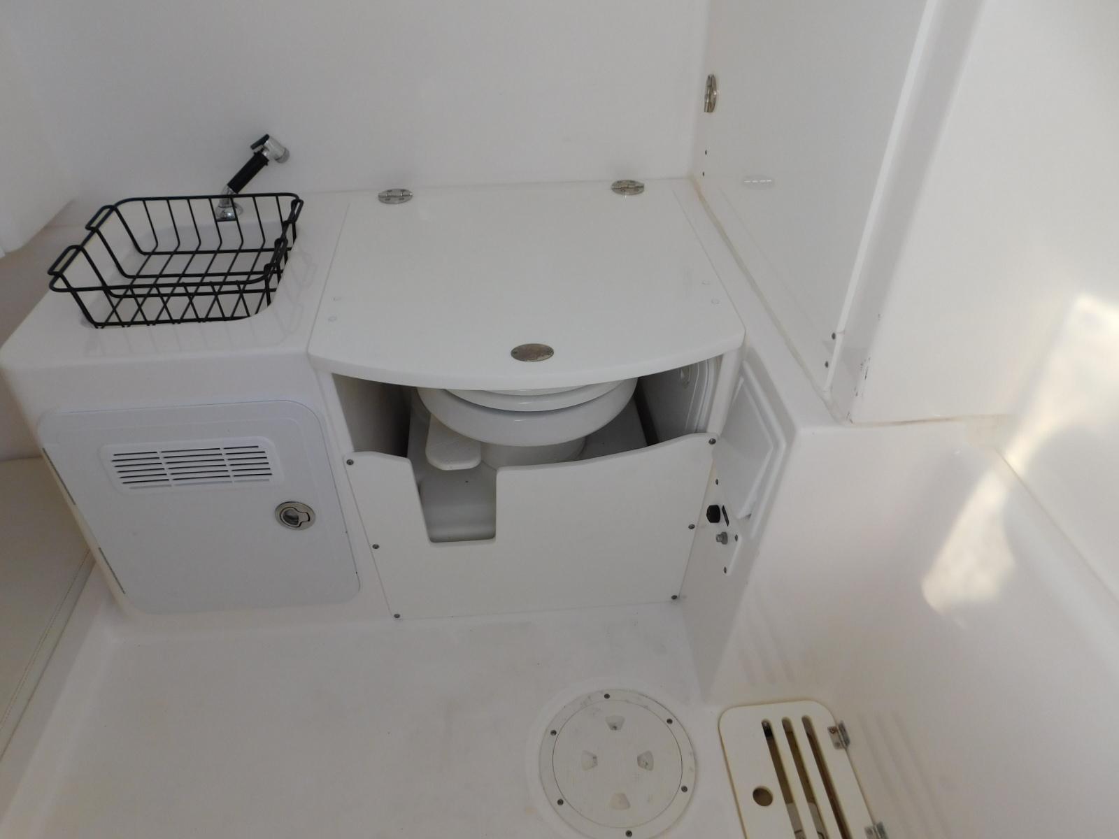 2016 Everglades 355 Center Console boat interior with compact marine toilet.