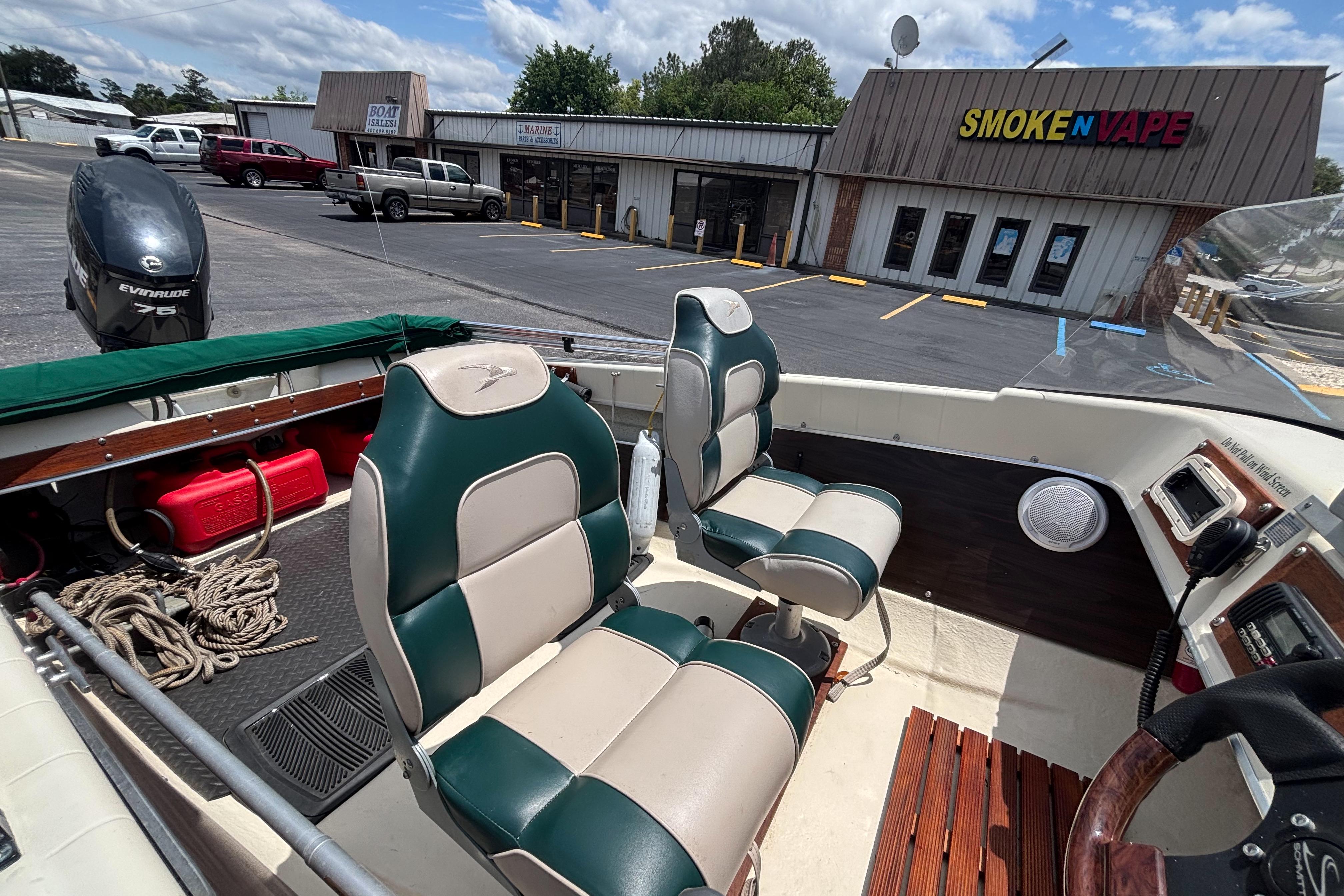 Interior of a 1966 Mohawk 15 boat with green and white seats, parked near a store.