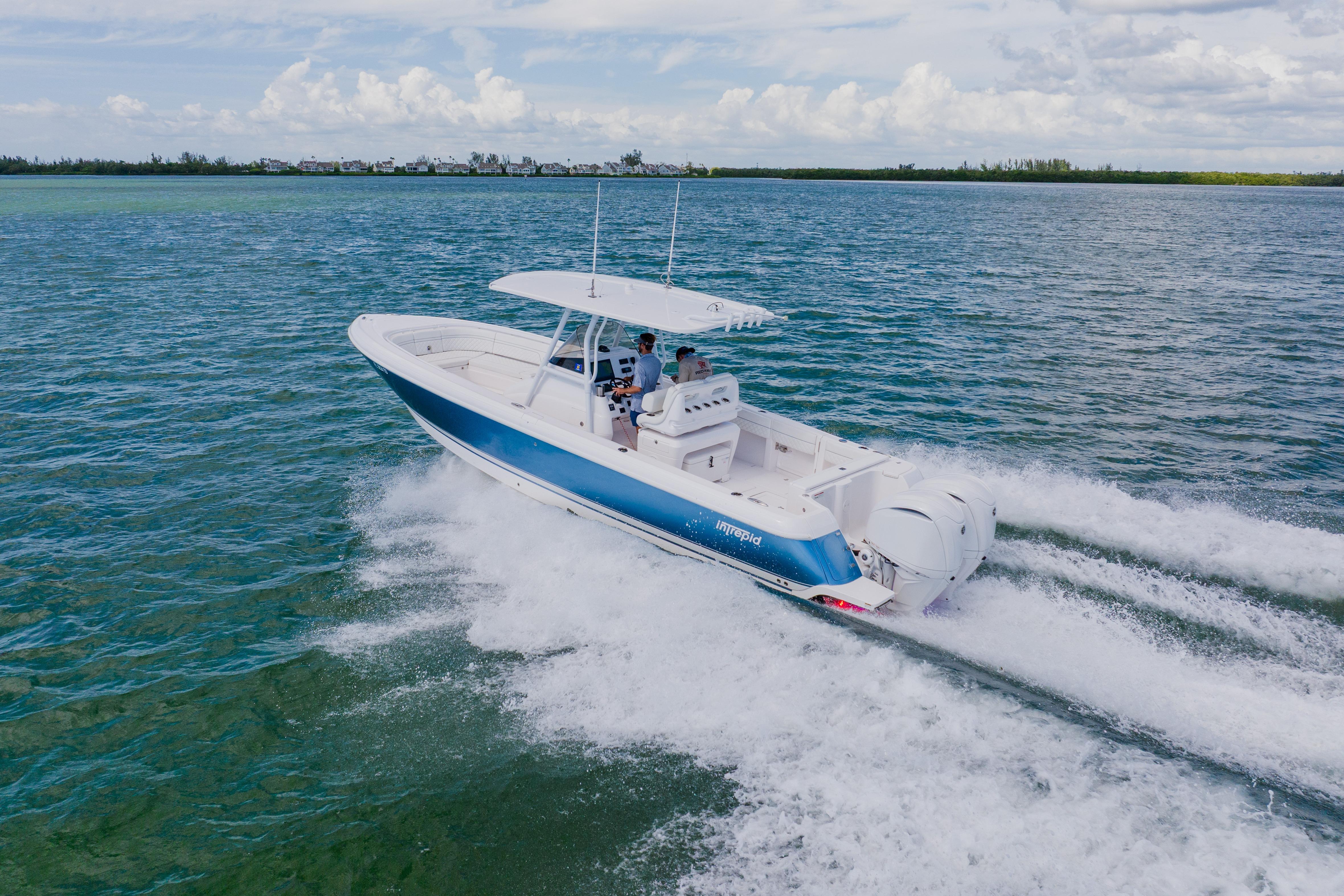 2018 Intrepid 327 Center Console boat cruising on open water, creating a wake.