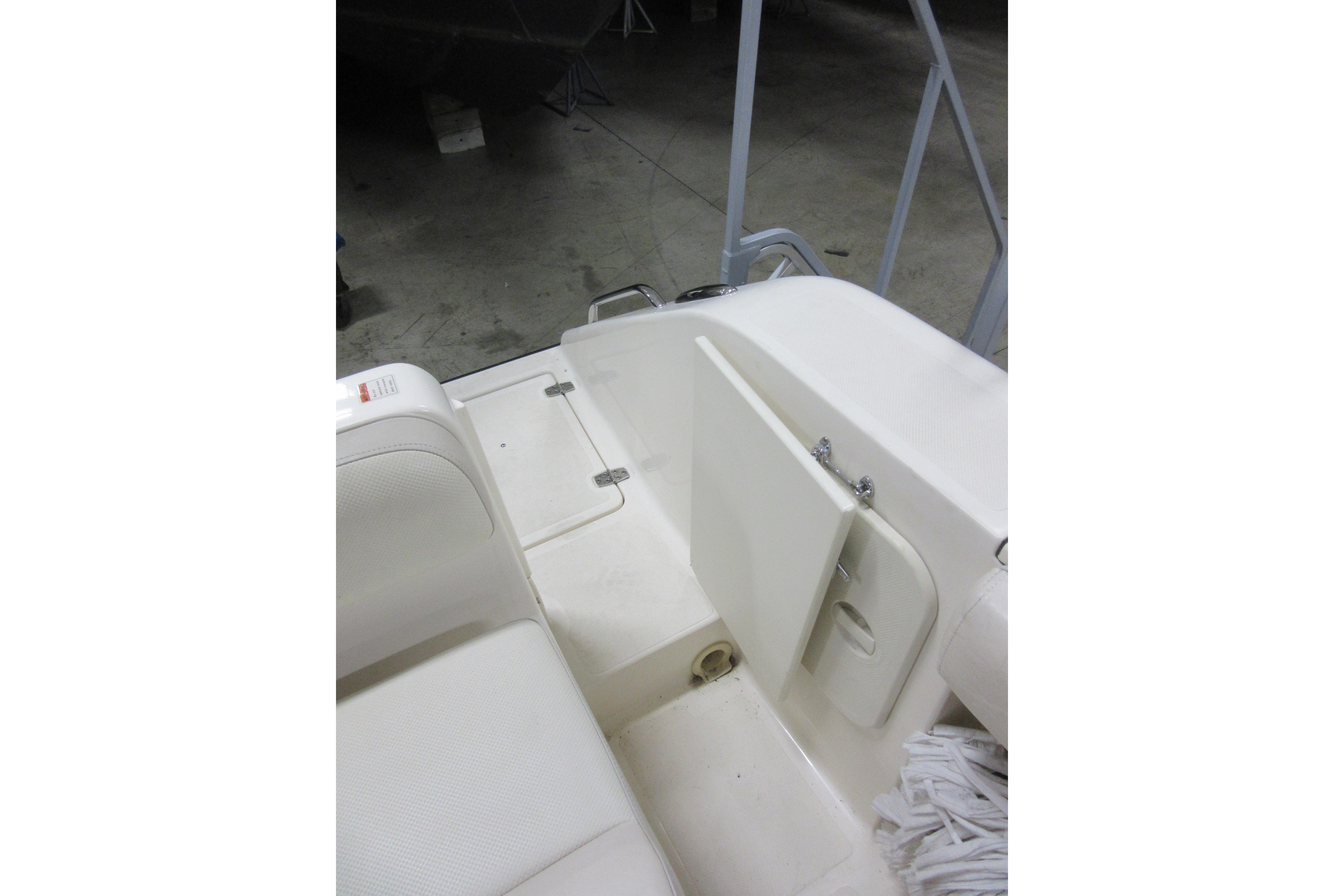 2011 Pursuit C 230 Center Console boat interior with white seating and storage compartment.
