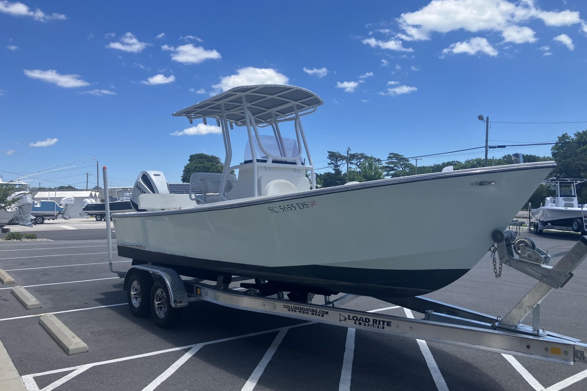 2022 May-Craft 2300 CCX boat on trailer in parking lot under blue sky.