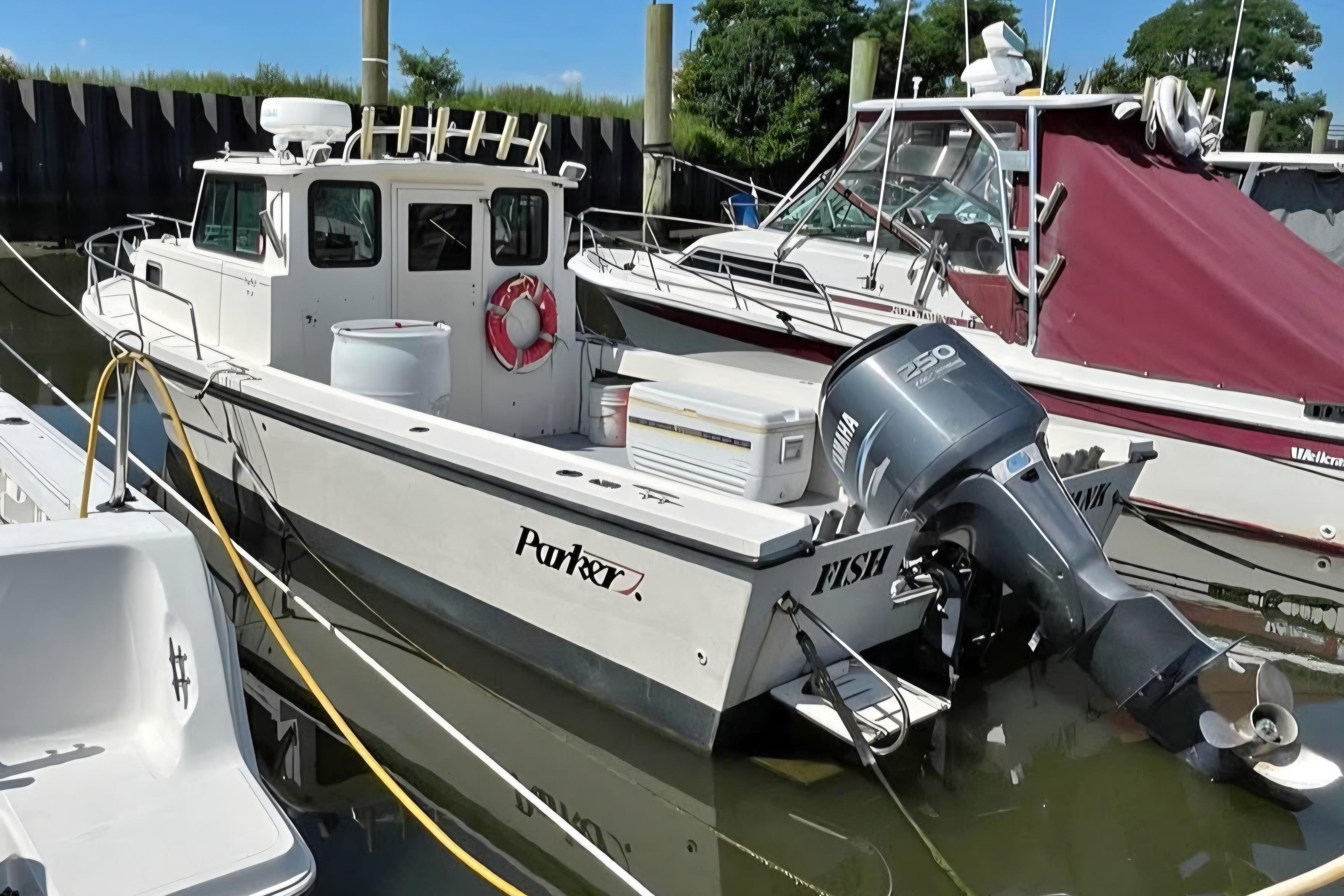 2002 Parker 2520 Deep Vee Sport Cabin boat docked with Yamaha outboard motor.