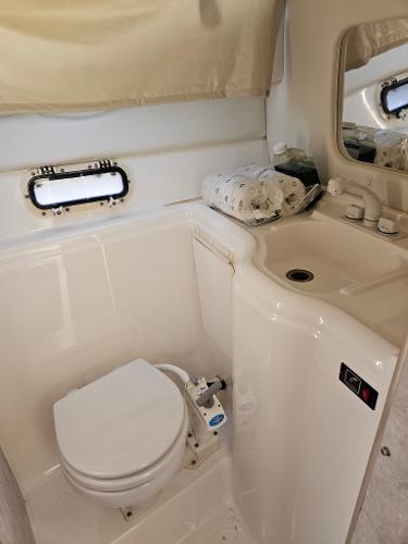 1997 Bayliner 26 Cierra boat bathroom with toilet, sink, and window.