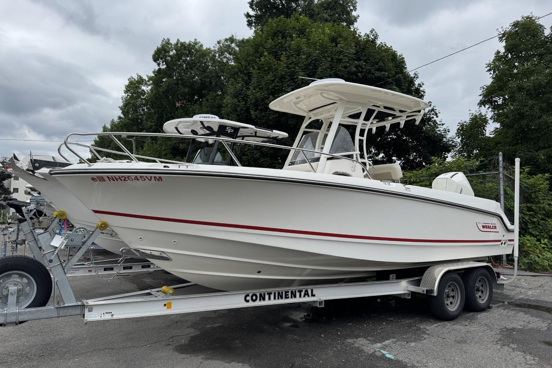 2024 Boston Whaler 230 Outrage boat on trailer, parked outdoors.