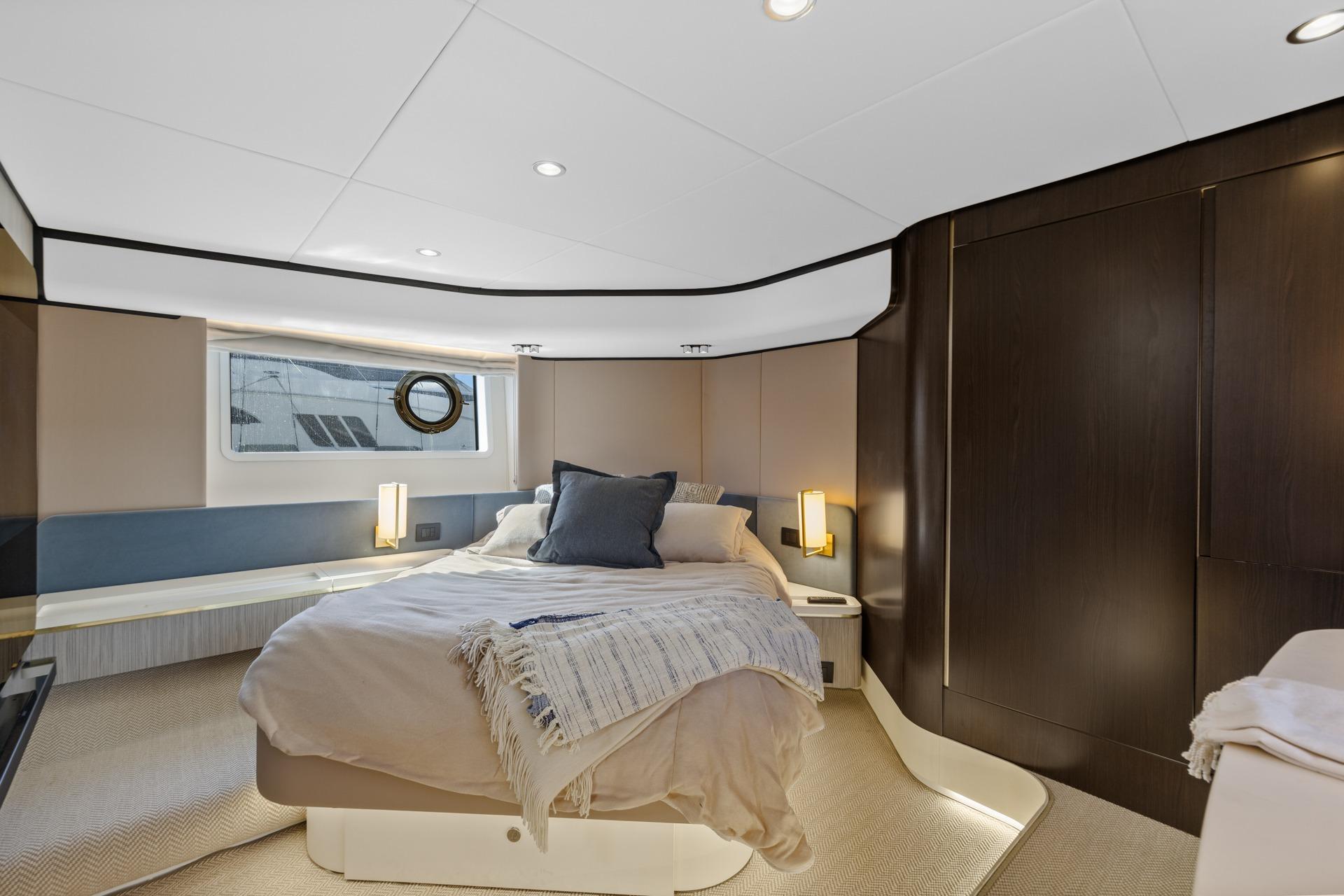 Luxurious bedroom interior of 2019 Azimut 55 yacht with modern design and cozy bedding.