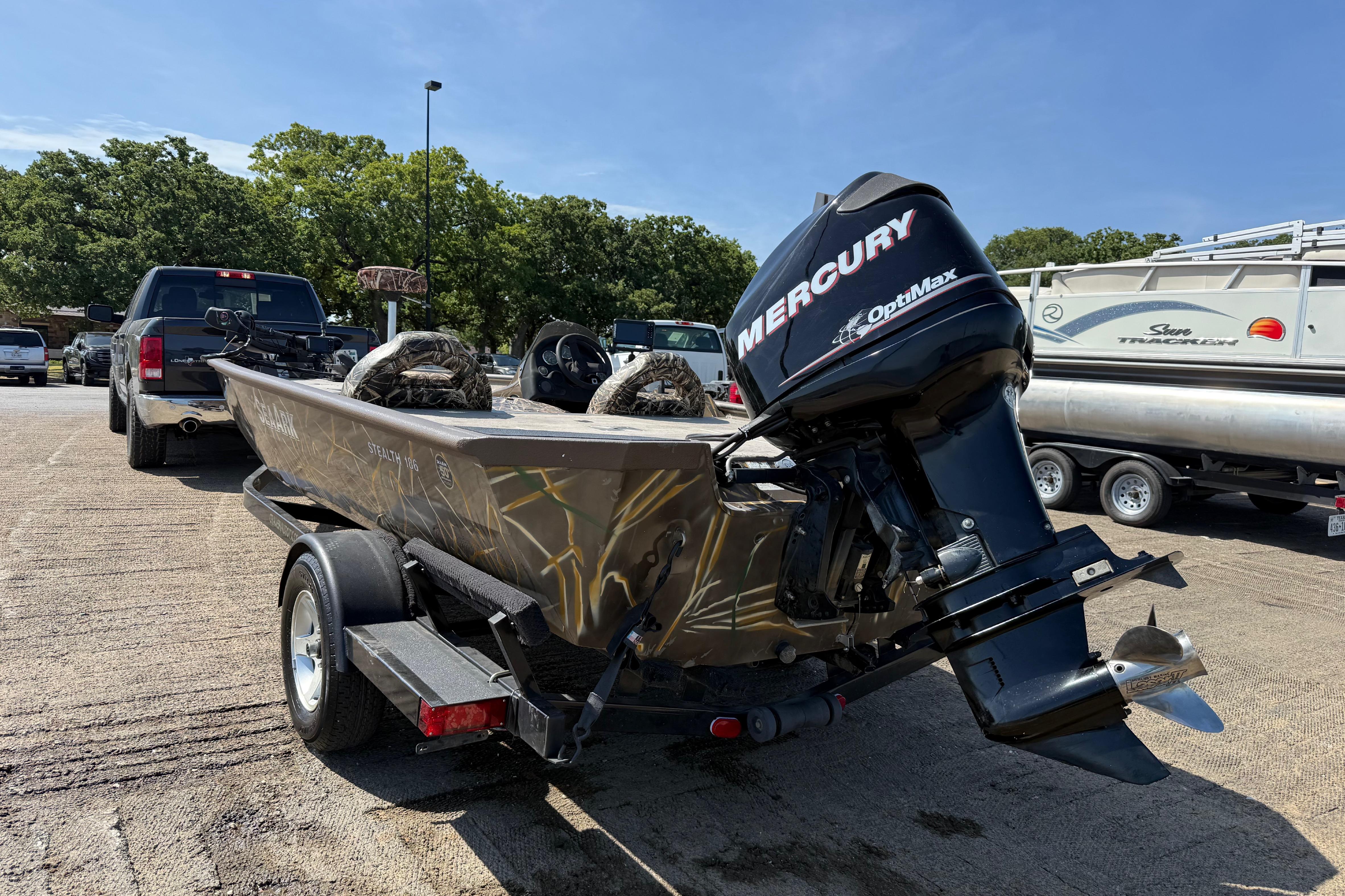 2010 SeaArk Stealth 190 boat with Mercury OptiMax engine on trailer.